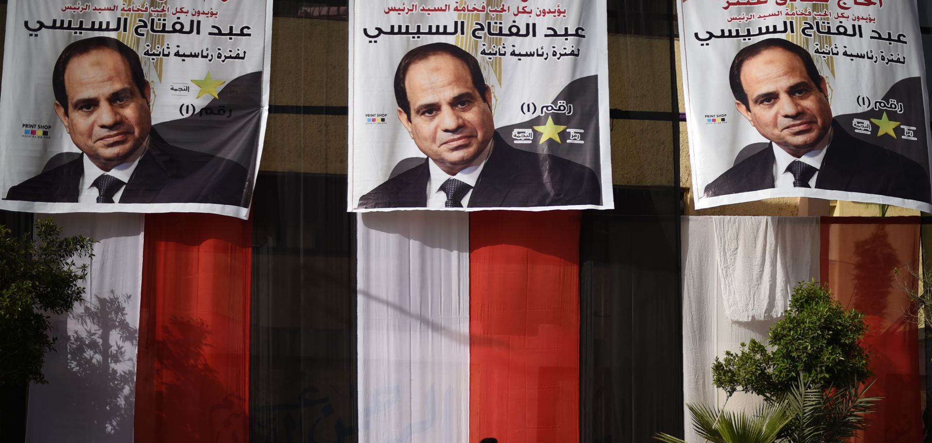 A young Egyptian passes a polling station in Cairo on March 25, 2018, the day before the presidential election kicks off. 