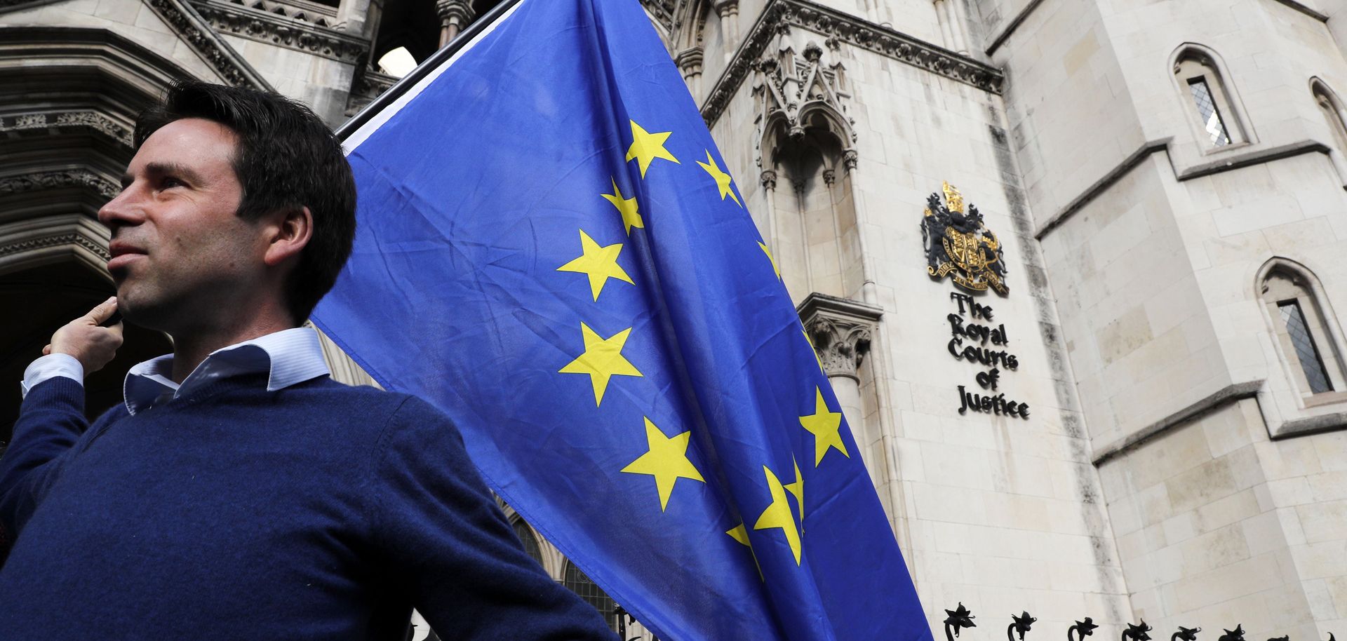 Pro-European Union supporter Phil Jones holds an EU flag outside the entrance to the Royal Courts of Justice, the United Kingdom's High Court, in London on Oct. 13, 2016.