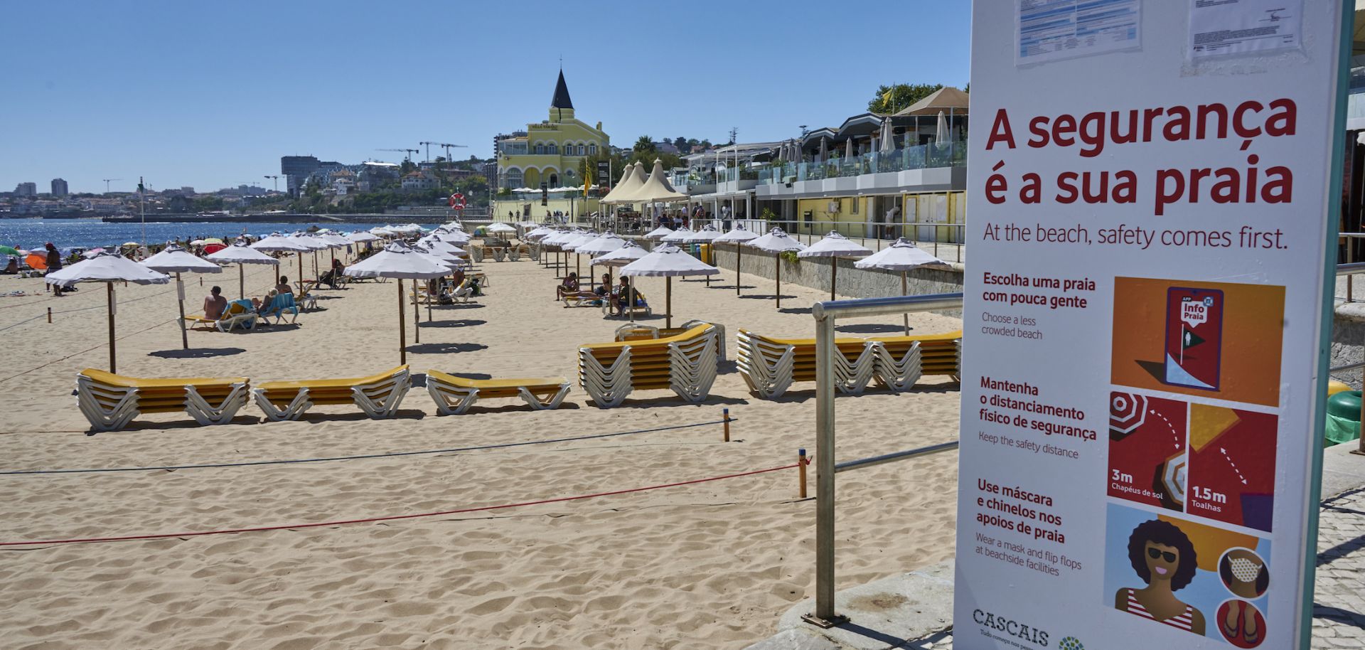 A large billboard alerts beachgoers of COVID-19 safety measures in Praia do Tamariz, a favorite spot for locals and tourists, on July 29, 2020, in Estoril, Portugal. 