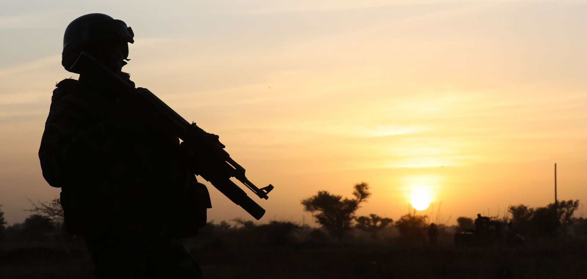 In this photo, a soldier stands guard in Niamey, Niger, on Dec. 22, 2019, while off-camera French President Emmanuel Macron and Nigerien President Mahamadou Issoufou pay tribute to 71 Nigerien soldiers killed during a Dec. 10, 2019, extremist attack on an army camp.