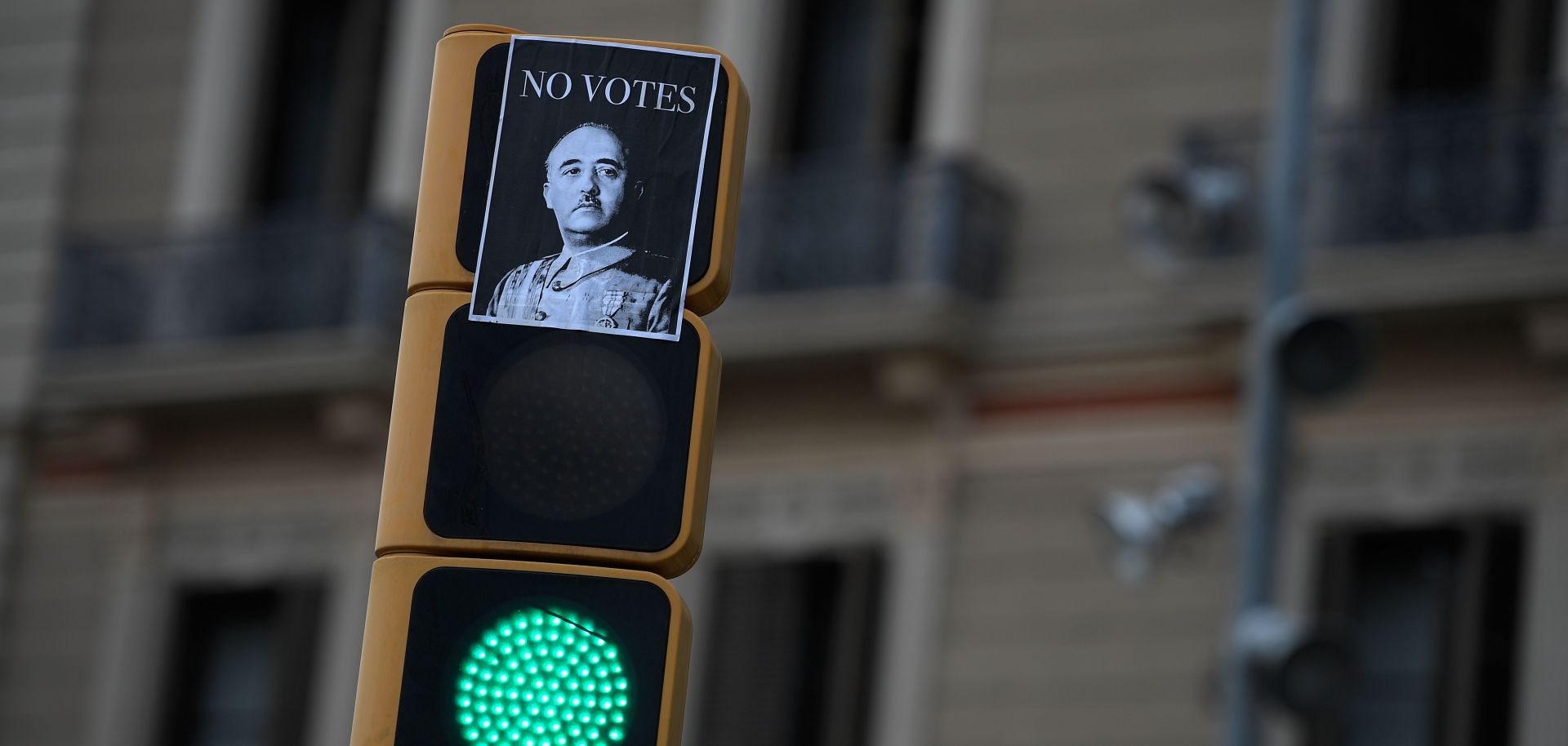 A picture taken on Sept. 23 shows a sticker depicting Spanish dictator Francisco Franco with a message reading "Don't vote" on a traffic light in downtown Barcelona. 