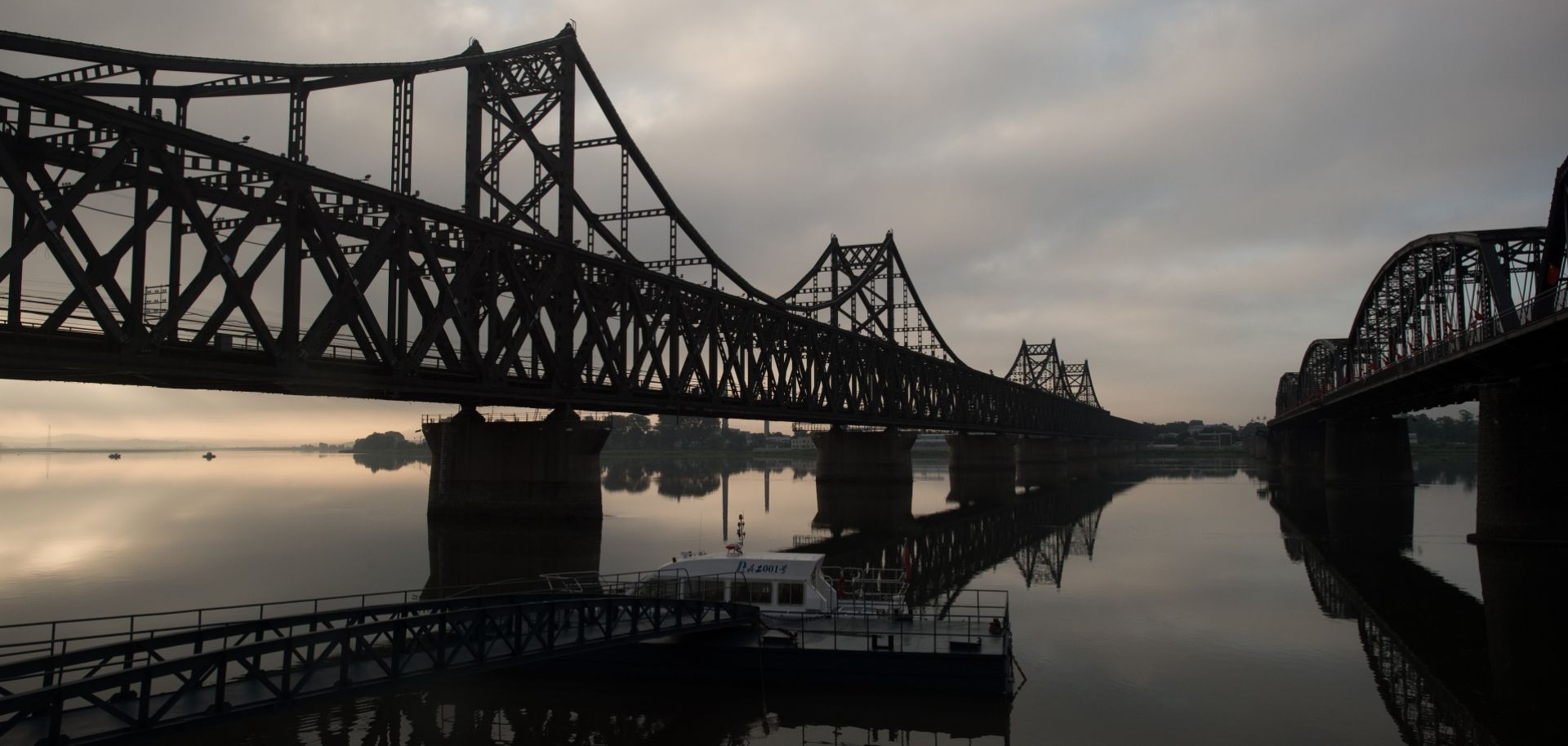 A picture showing the The sun rising over the Sino-Korean Friendship bridge on the Yalu River, connecting the North Korean town of Sinuiju and the Chinese border city of Dandong.
