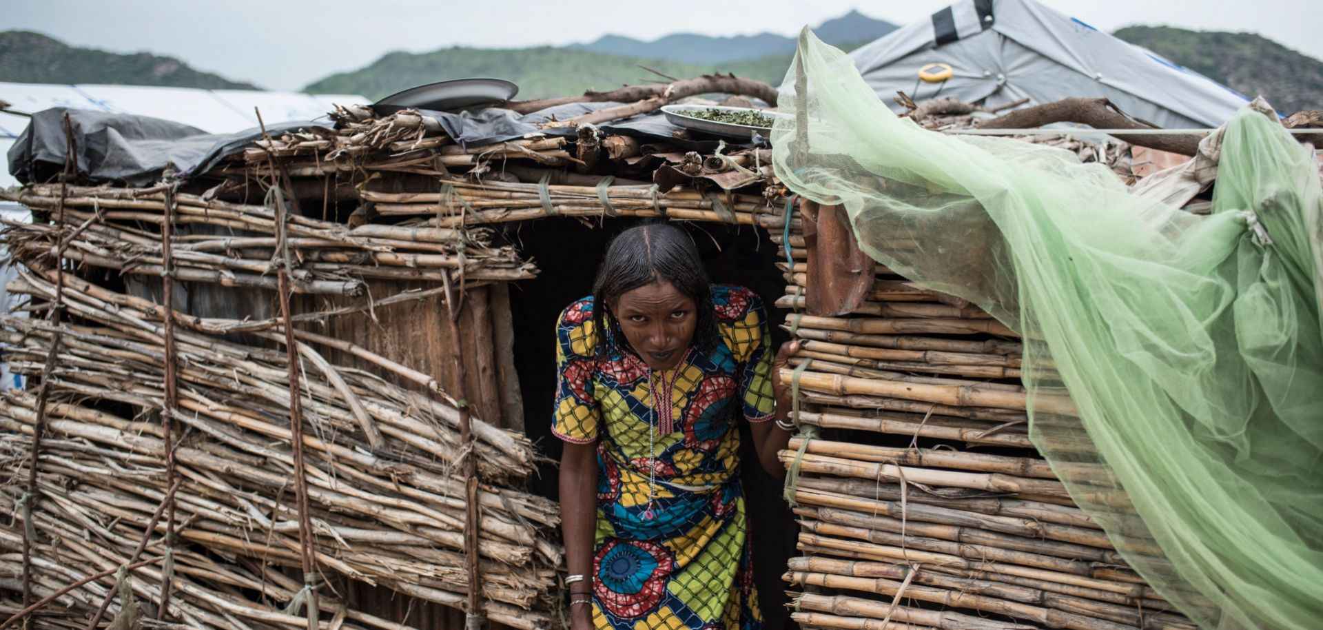 A Fulani woman, forced into a camp for internally displaced persons by violence in northeastern Nigeria, emerges from her temporary dwelling.