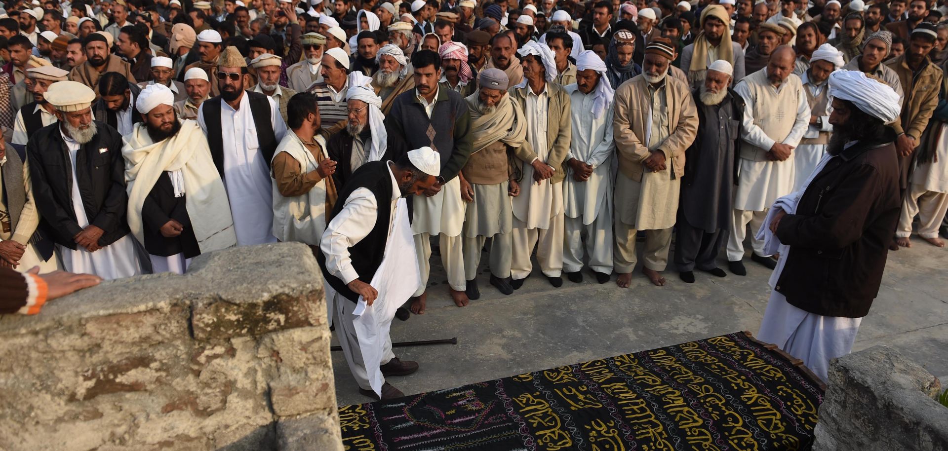 Family members gather to perform the funeral prayer for Arshad Mehmood.