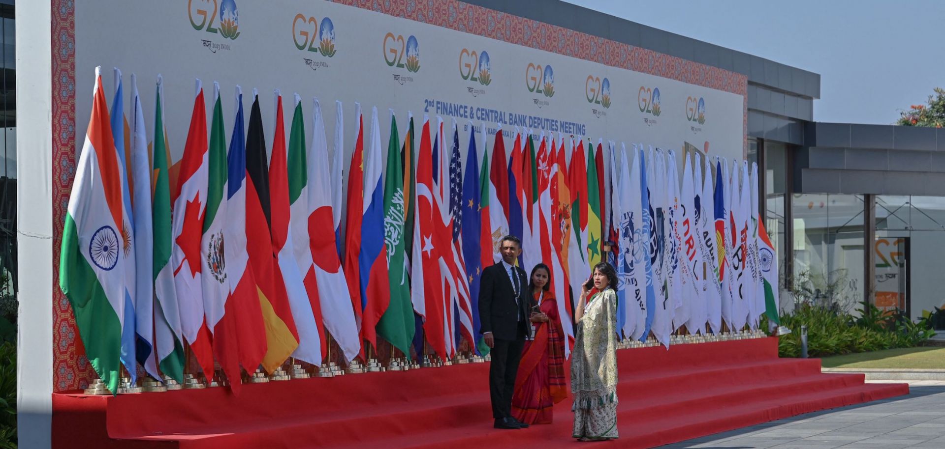 Officials stand near flags of participating countries and organizations at the venue where the second meeting of the G-20 Finance and Central Bank Deputies under India's G-20 presidency has begun Feb. 22, 2023, in Bengaluru, India.