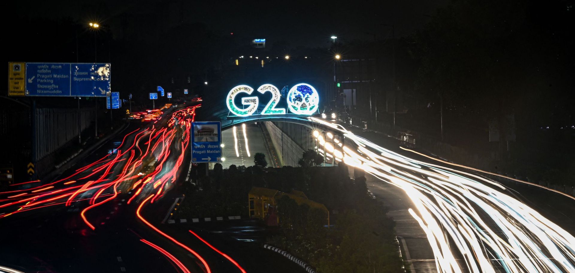 Vehicles drive past the logo of the G-20 Summit on Aug. 10, 2023, in New Delhi.