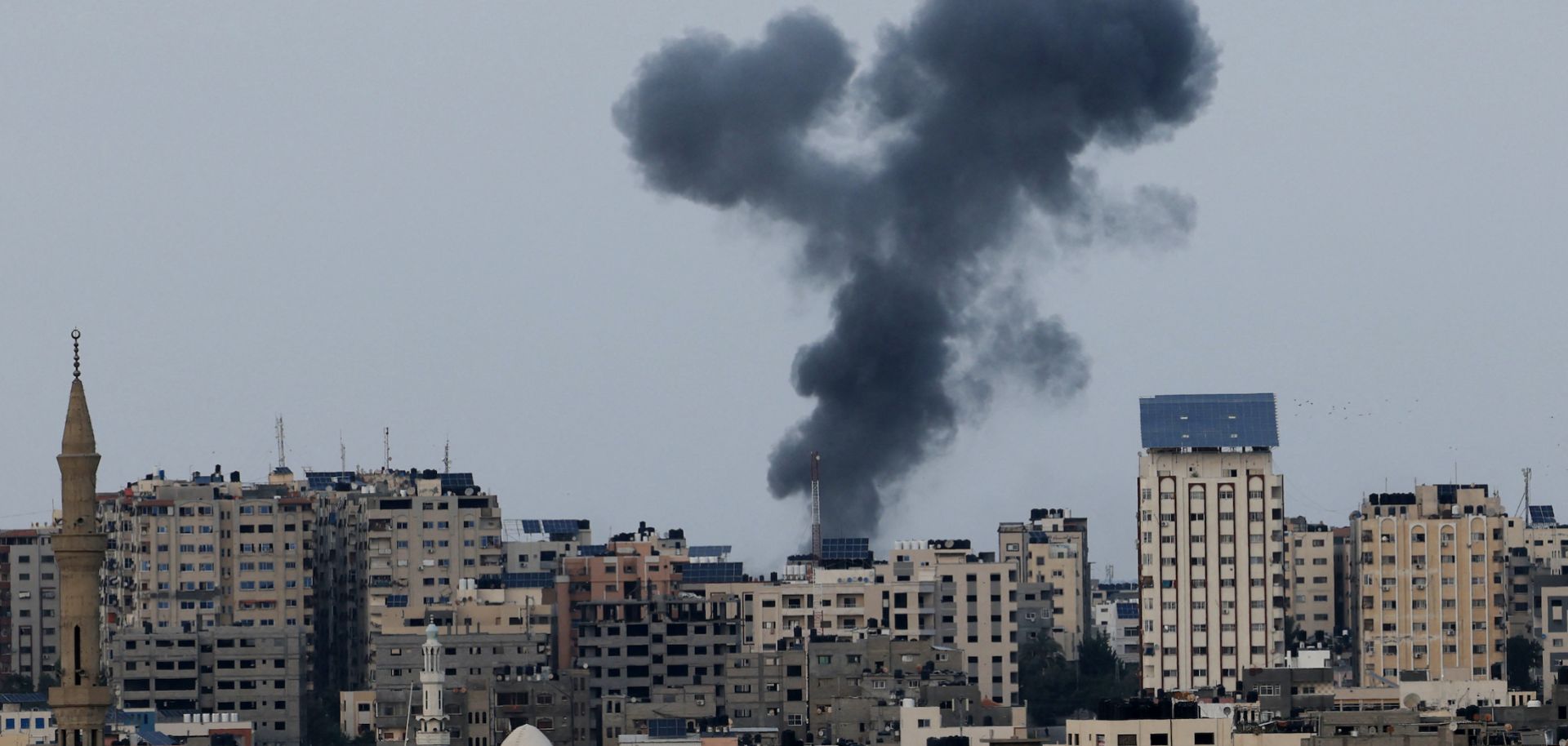 A plume of black smoke rises above Gaza City's skyline during an Israeli air strike on Oct. 8, 2023. 