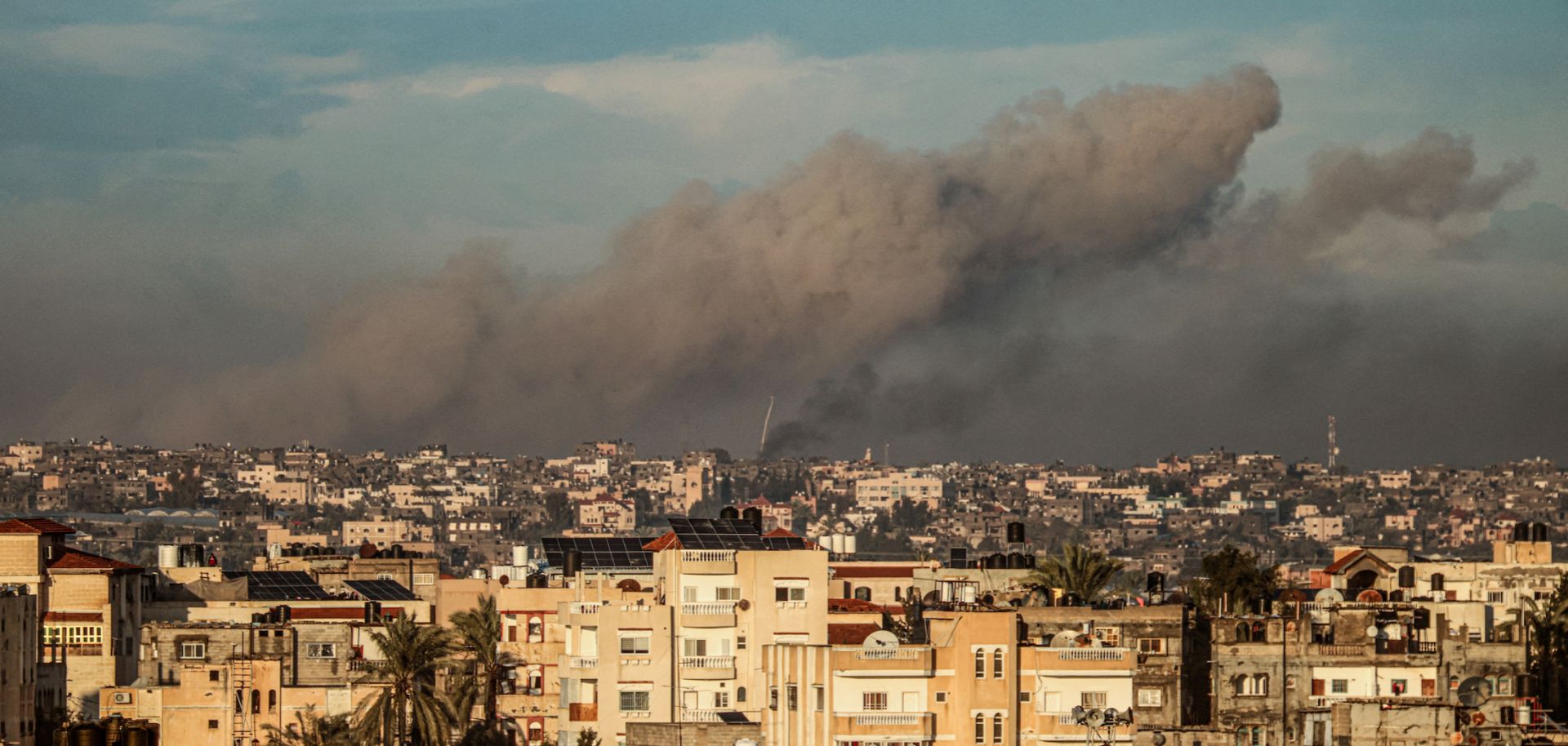 A picture taken from Rafah in the southern Gaza Strip shows smoke rising over buildings in Khan Yunis during an Israeli bombardment on Feb. 2, 2024. 