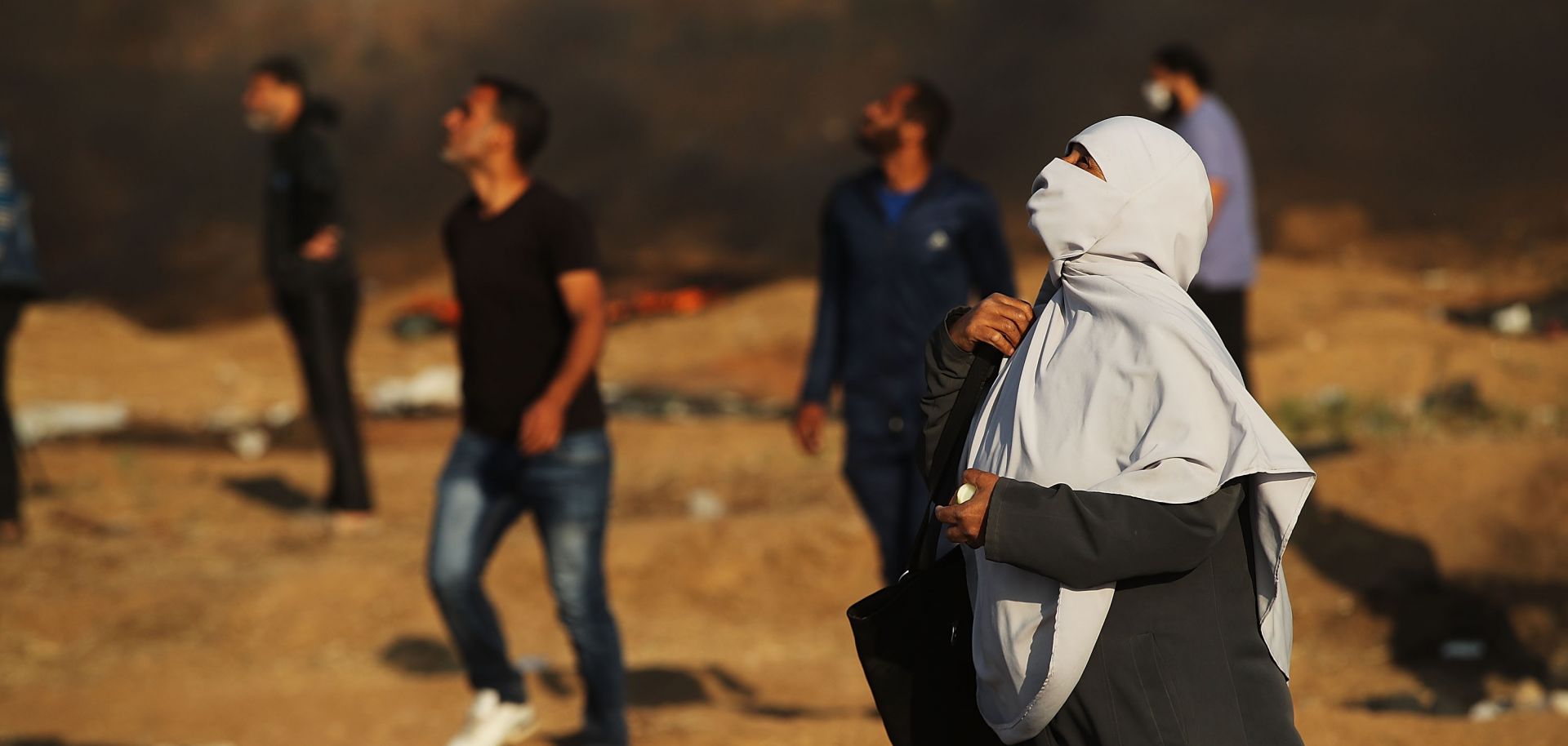 Palestinian protesters in Gaza look skyward as an Israeli drone shoots tear gas canisters toward them on May 15, 2018.