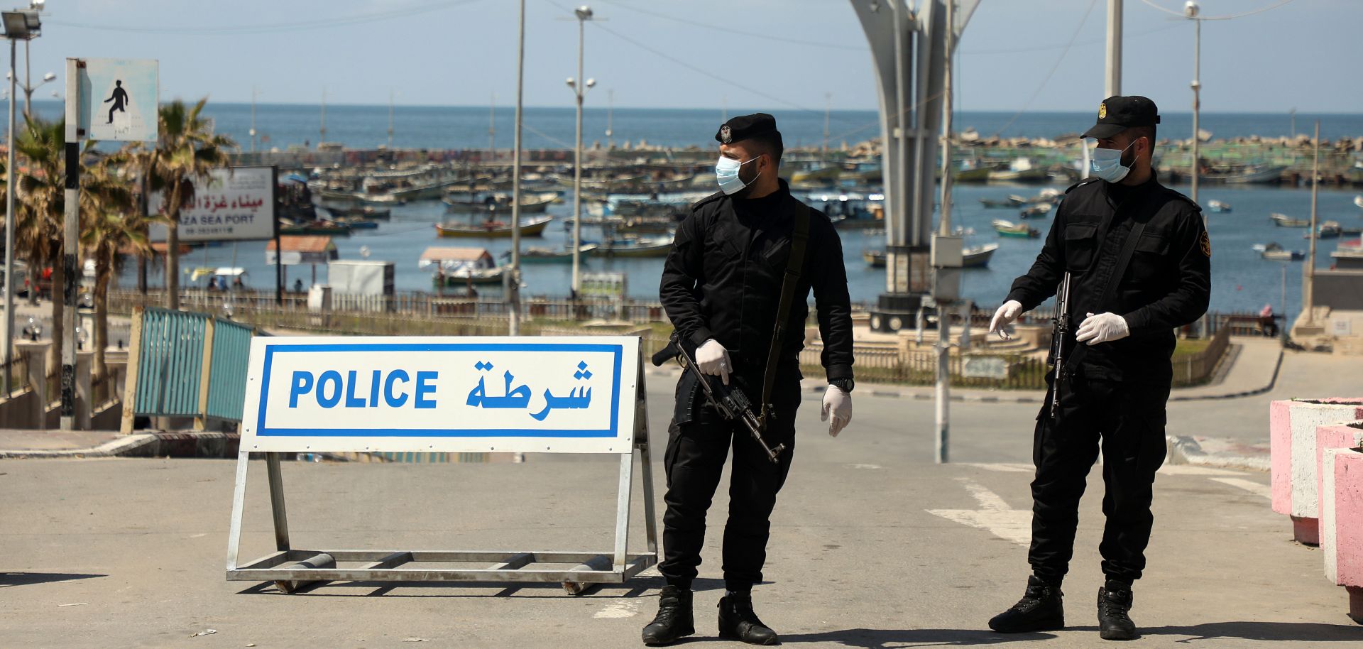 Security forces loyal to Hamas wear face masks while they guard the entrance to the seaport in Gaza City on March 25, 2020. The Palestinian city in the Gaza Strip has been on lockdown to stem the spread of COVID-19.