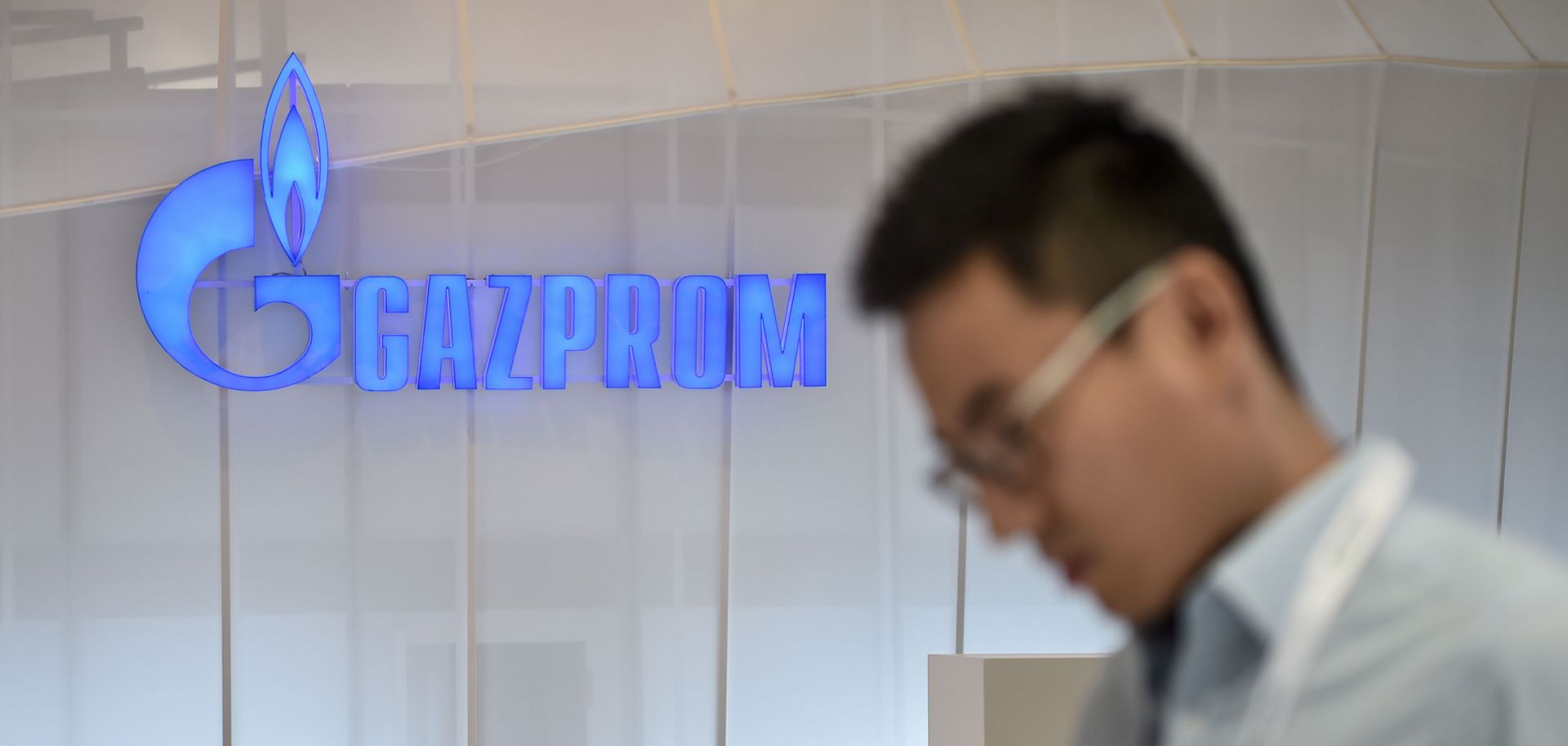 A man looks at his mobile phone as he walks past a Russian Gazprom stand in Istanbul. 