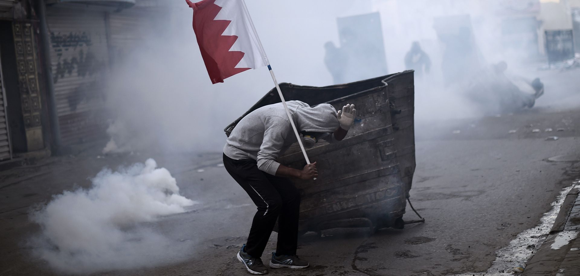 A Bahraini protester takes cover during clashes with police on the outskirts of Manama in 2015. 