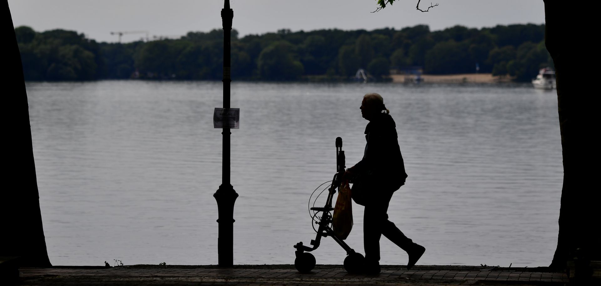 A woman uses an aid to walk along Berlin's Lake Tegel in June 2017.