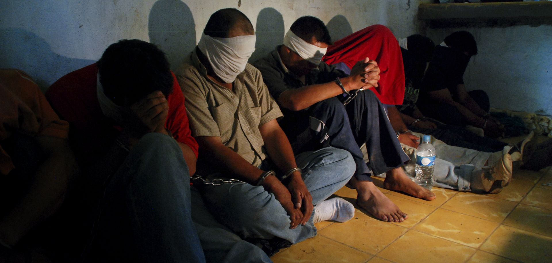 A group of people kidnapped by alleged drug-traffickers, sit on the floor after being rescued.