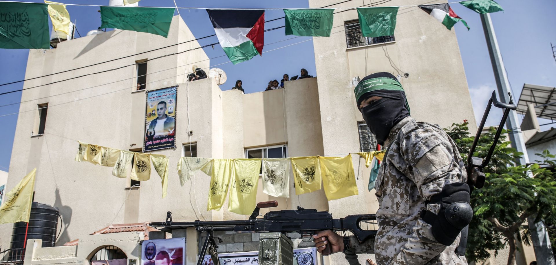 A masked Hamas militant mans a machine gun in the back of a pickup truck in the Palestinian city of Rafah, located in the southern Gaza Strip, on Oct. 17, 2019. The yellow flags of the Palestinian party Fatah can also be seen in the background. 