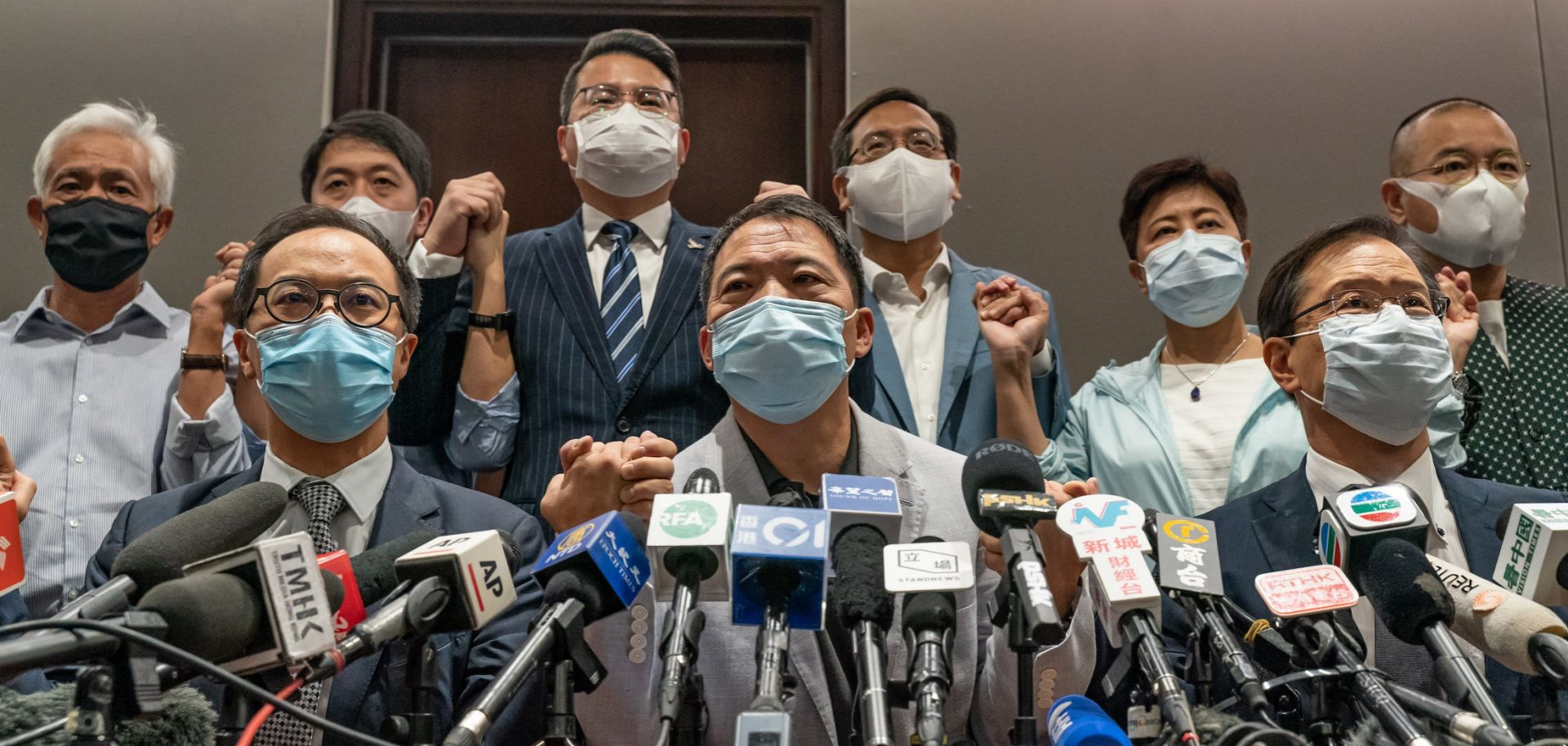 Pro-democracy lawmakers join hands during a press conference at Hong Kong’s Legislative Council after city officials ousted four of their colleagues on Nov. 11, 2020