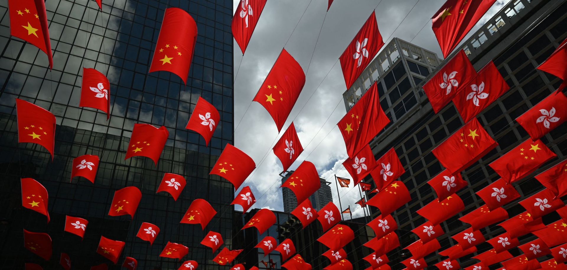 Chinese and Hong Kong flags are strung between buildings to mark the 26th anniversary of the city's handover from Britain to China on June 27, 2023, in Hong Kong.