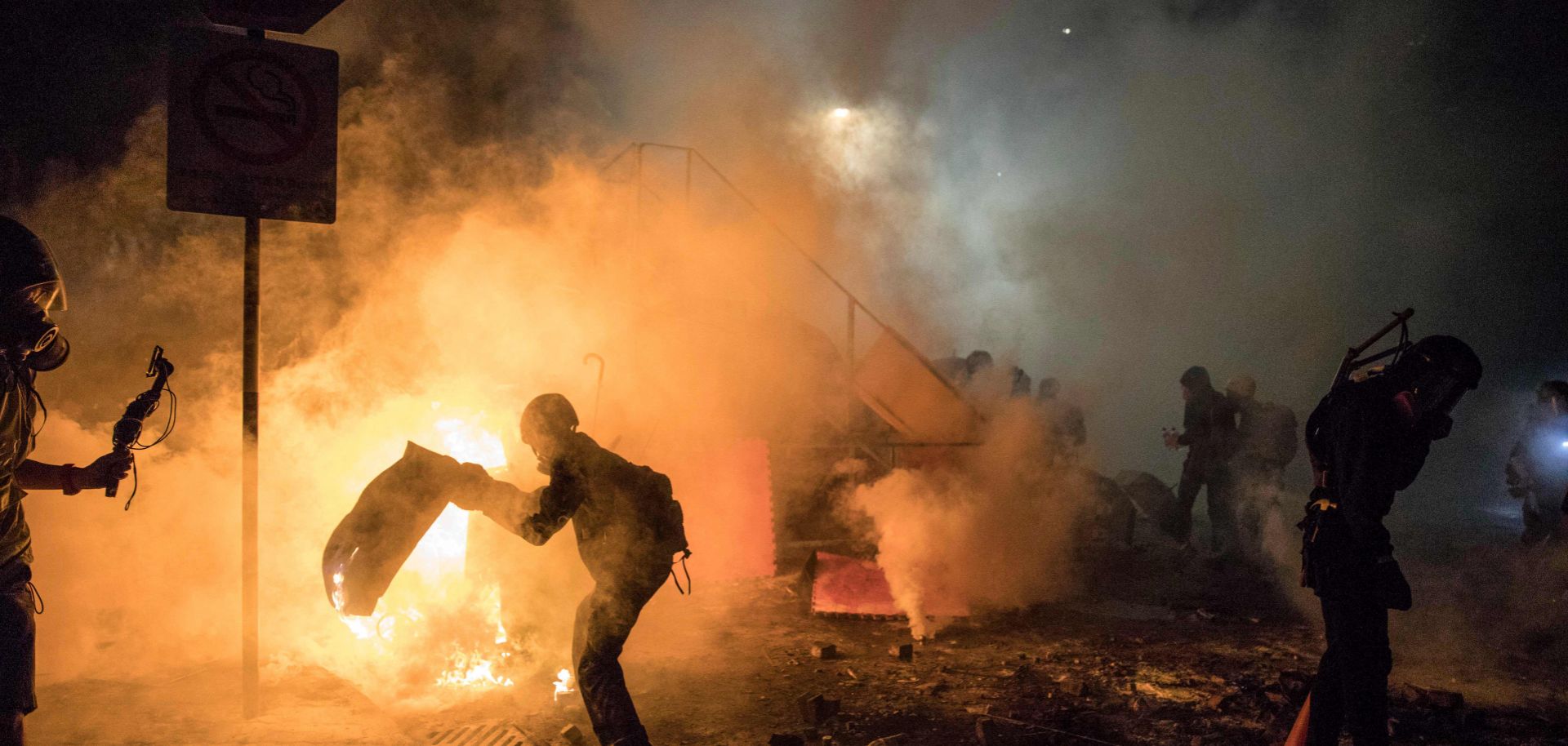 A barricade burns during clashes between protesters and police at the Chinese University of Hong Kong (CUHK) on November 12, 2019. Hong Kong pro-democracy protesters clashed with riot police in the city's upmarket business district and on university campuses, extending one of the most violent stretches of unrest seen in more than five months of political chaos in the city.
