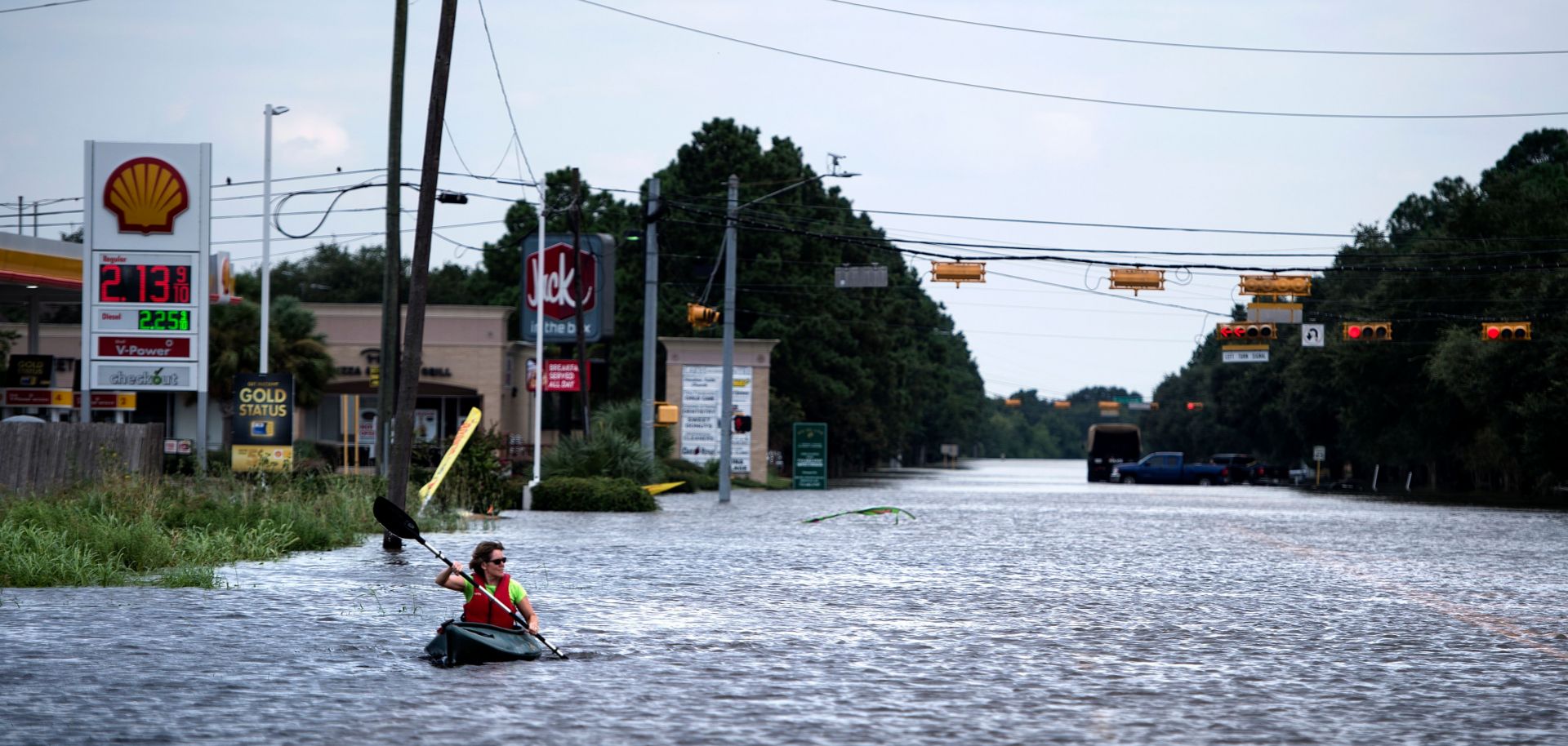 A woman in a kayak paddles down a Houston road flooded in late August by rains from Hurricane Harvey.