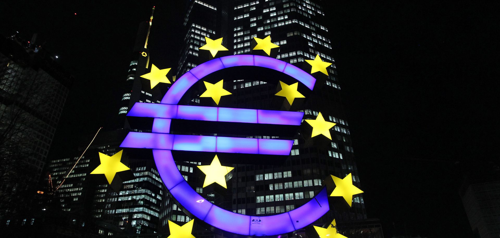 The illuminated sculpture by German artist Ottmar Hoerl's depicting the Euro is seen in front of the European Central Bank.