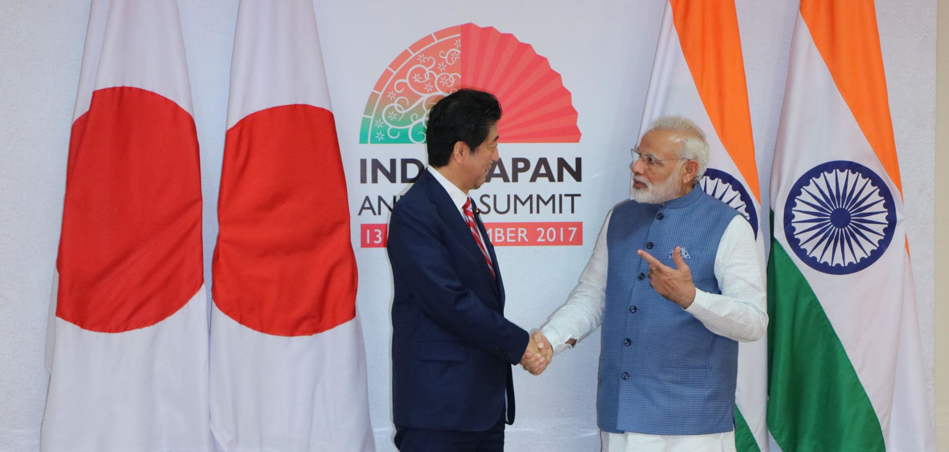 Indian Prime Minister Narendra Modi (right) shakes hand with Japanese Prime Minister Shinzo Abe during the annual India-Japan summit on Sept. 14, 2017. Behind the two world leaders are their countries' respective flags. 