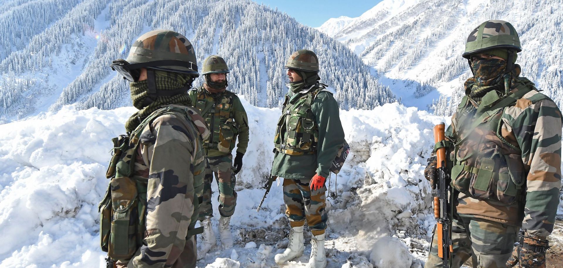 Indian army soldiers stand on a snow-covered road near Zojila mountain pass that connects Srinagar to the union territory of Ladakh, bordering China