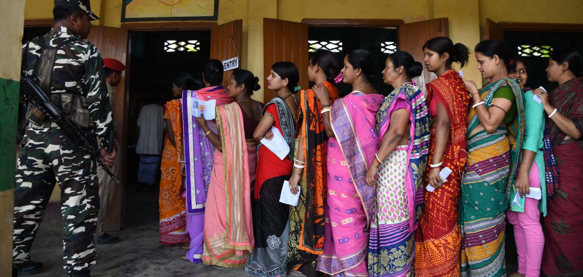 Indian voters stand in line to cast their votes.