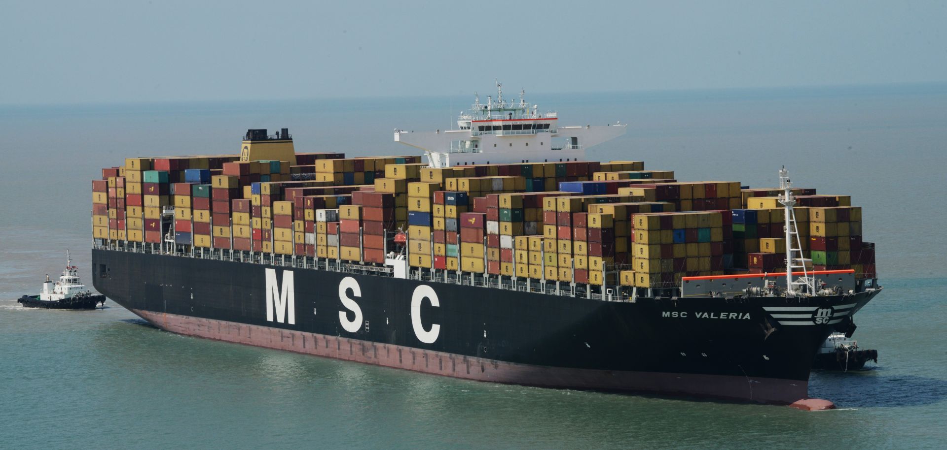 Tugboats maneuver the MSC Valeria as it arrives in Mundra, India, in June 2013.