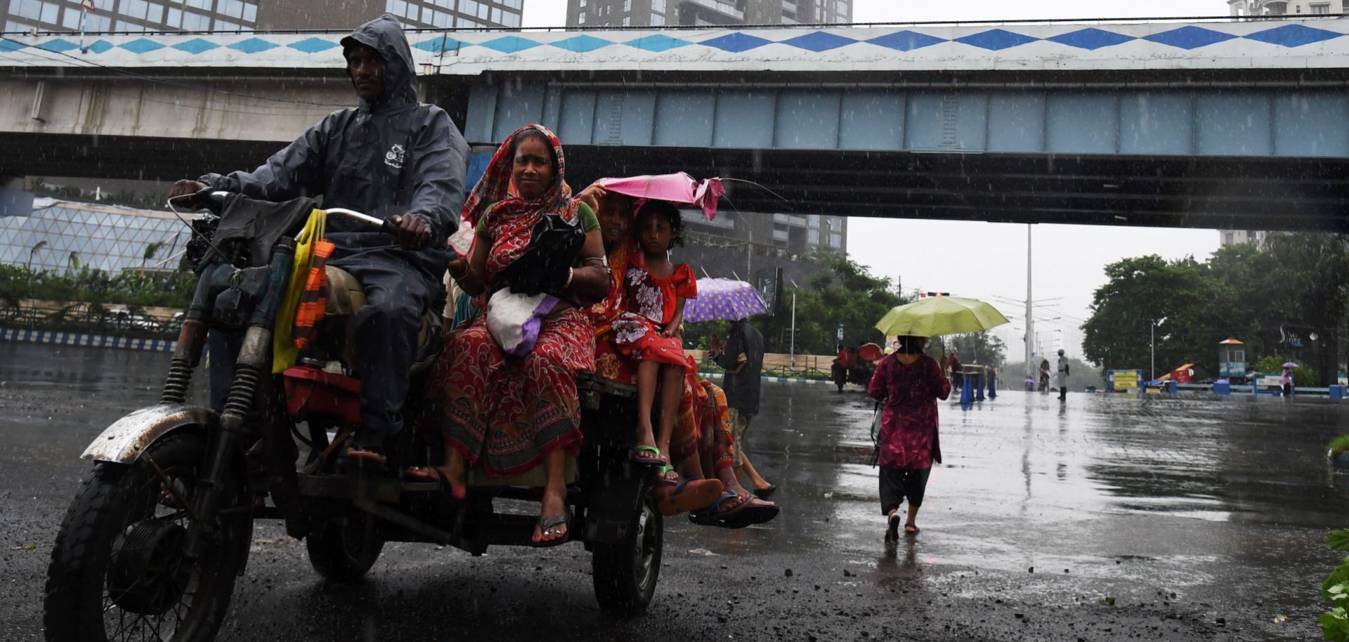 Passengers in Kolkata make their daily commute through a monsoon July 24, 2017.