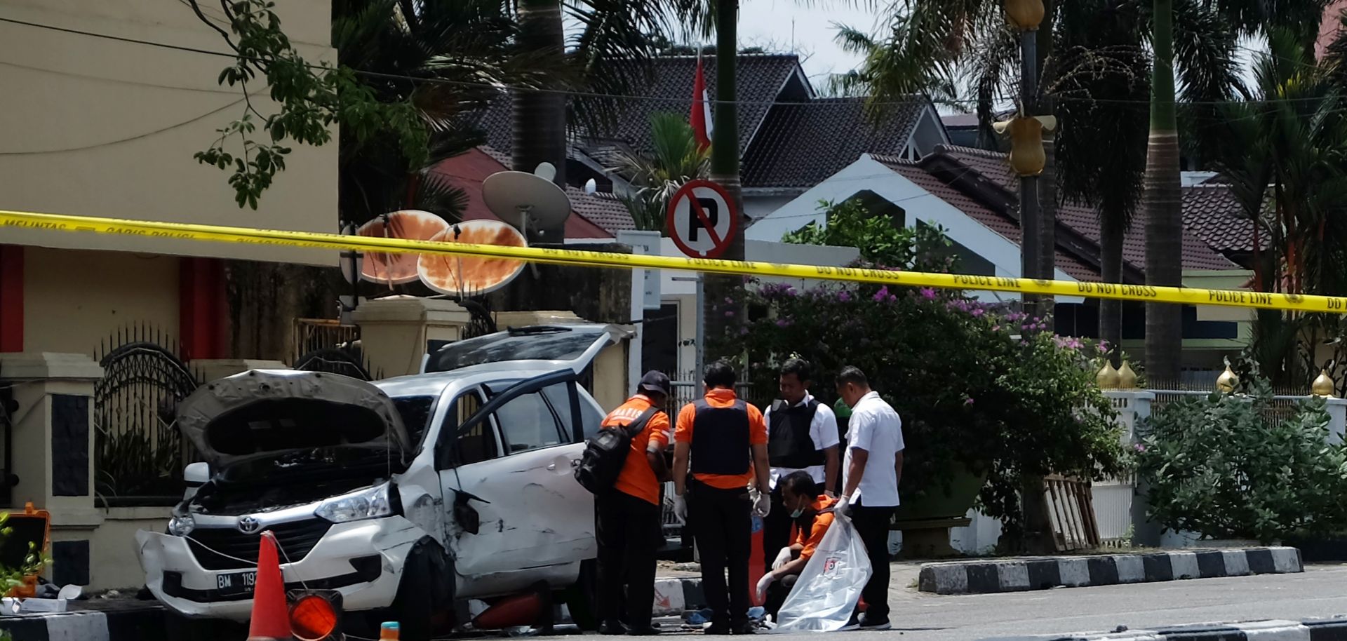 In this photograph, police in Indonesia examine a minivan used five men to attack a police headquarters in Pekanbaru, Riau, on May 16, 2018.