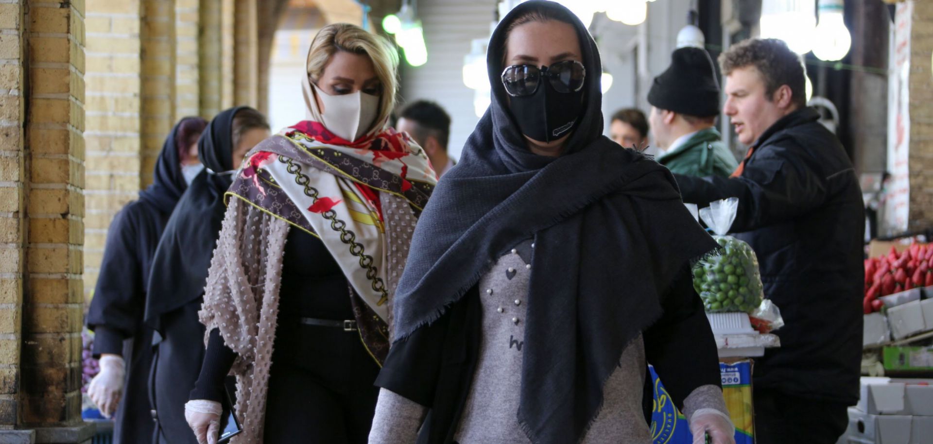 Shoppers wear protective face masks in a bid to prevent the spread of COVID-19 in a market on April 5, 2020, in the Iranian capital of Tehran. 