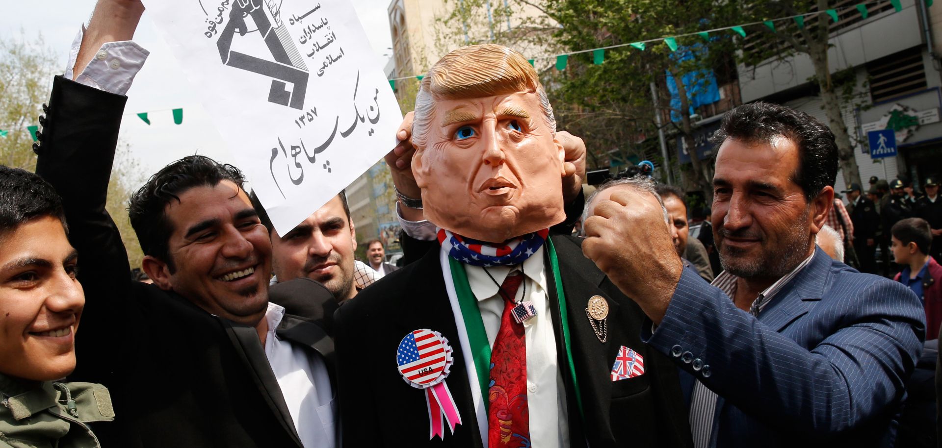 Protesters pretend to hit a man wearing a mask of U.S. President Donald Trump during an April 12, 2019, rally in the Iranian capital of Tehran.
