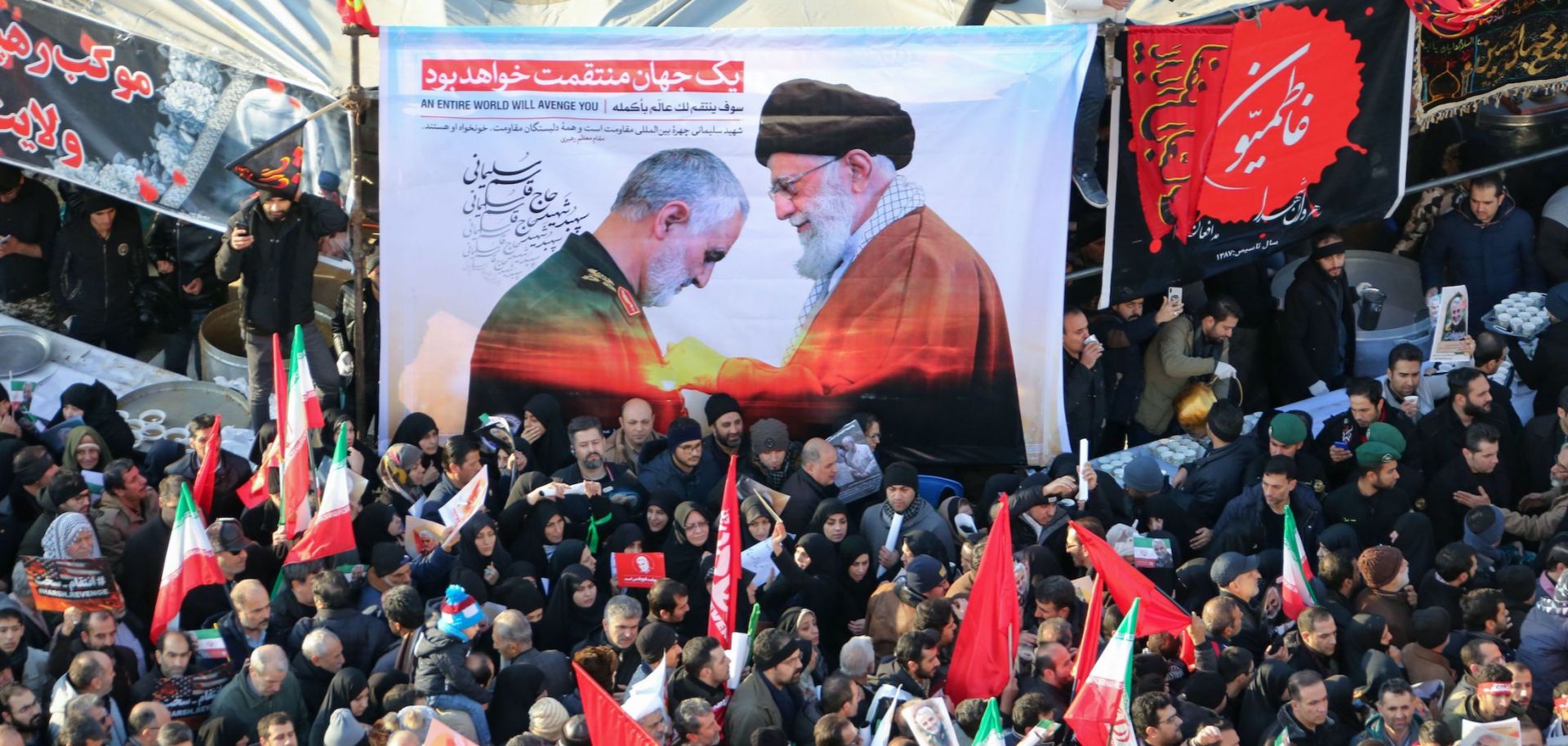 Mourners in Tehran carry a banner featuring Maj. Gen. Qassem Soleimani and Supreme Leader Ayatollah Ali Khamenei during the military leader's funeral procession on Jan. 6.