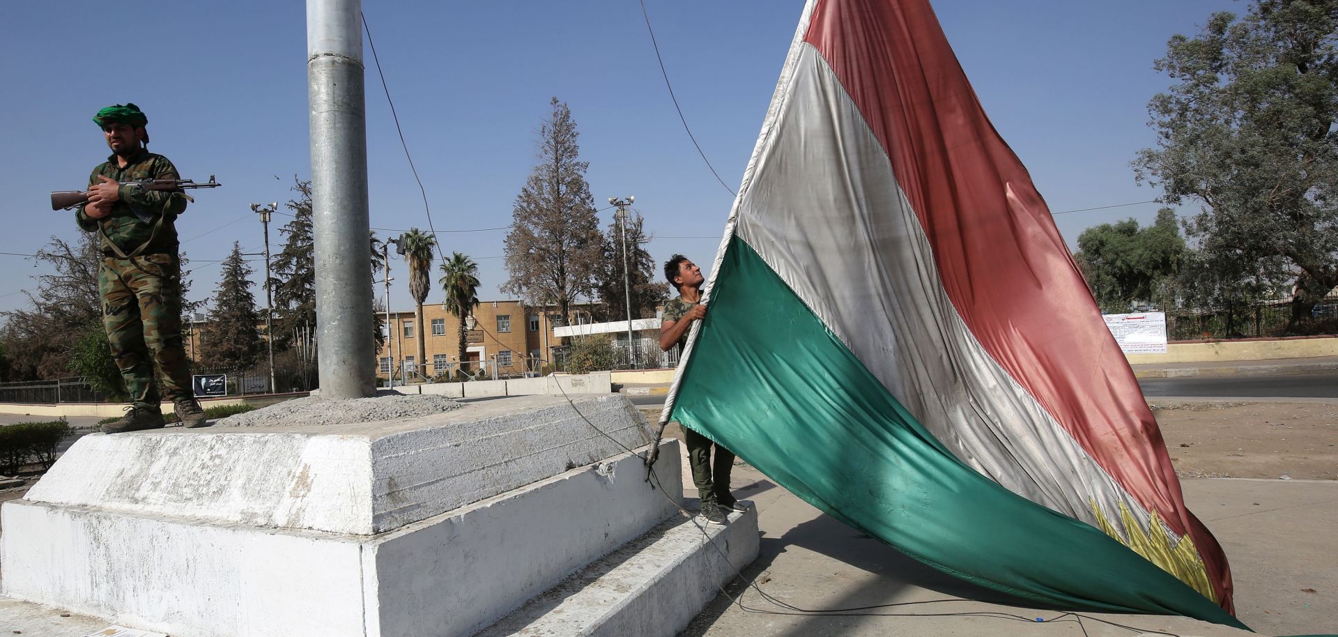 A member of the Iraqi security forces takes down a Kurdish flag in Kirkuk on Oct. 16, 2017. 