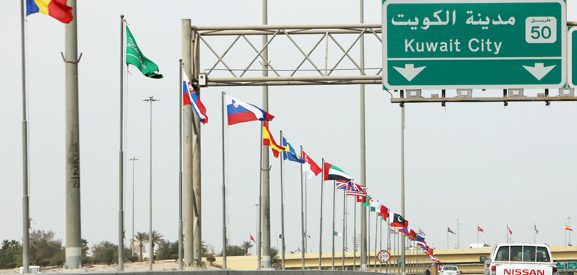 The flags of 70 countries fly in Kuwait City on Feb. 9. Kuwait is hosting an international Iraq reconstruction conference this week.