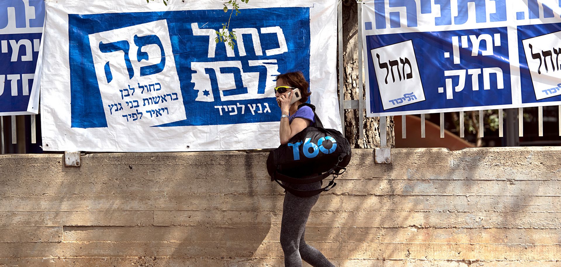 This photo shows a woman walking past election banners in Tel Aviv during Israel's elections on April 9, 2019.