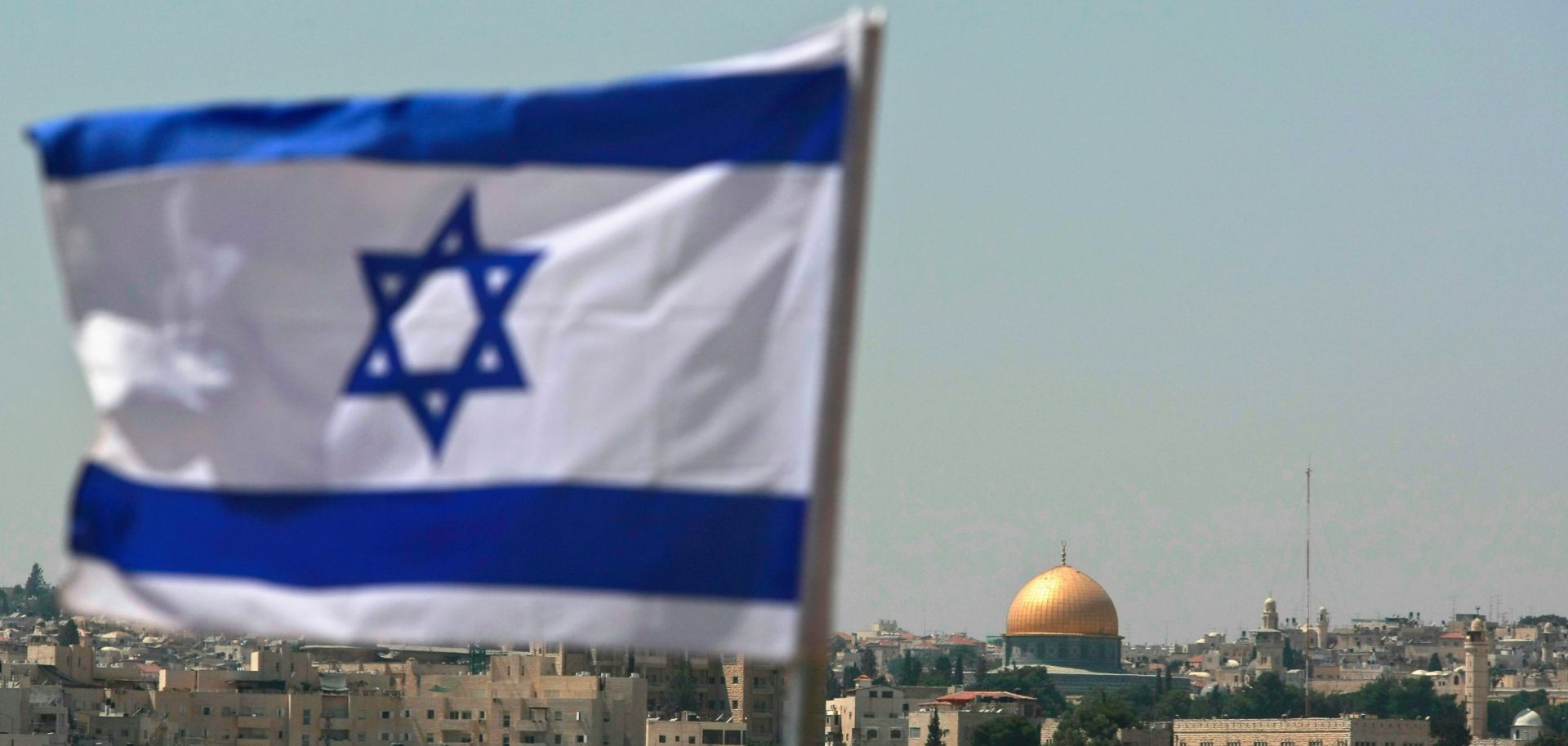 An Israeli flag flies over the city of Jerusalem. 