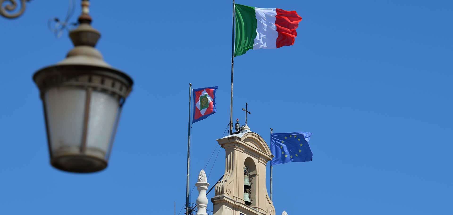 The Italian and EU flags fly over the Quirinale Palace in Rome.