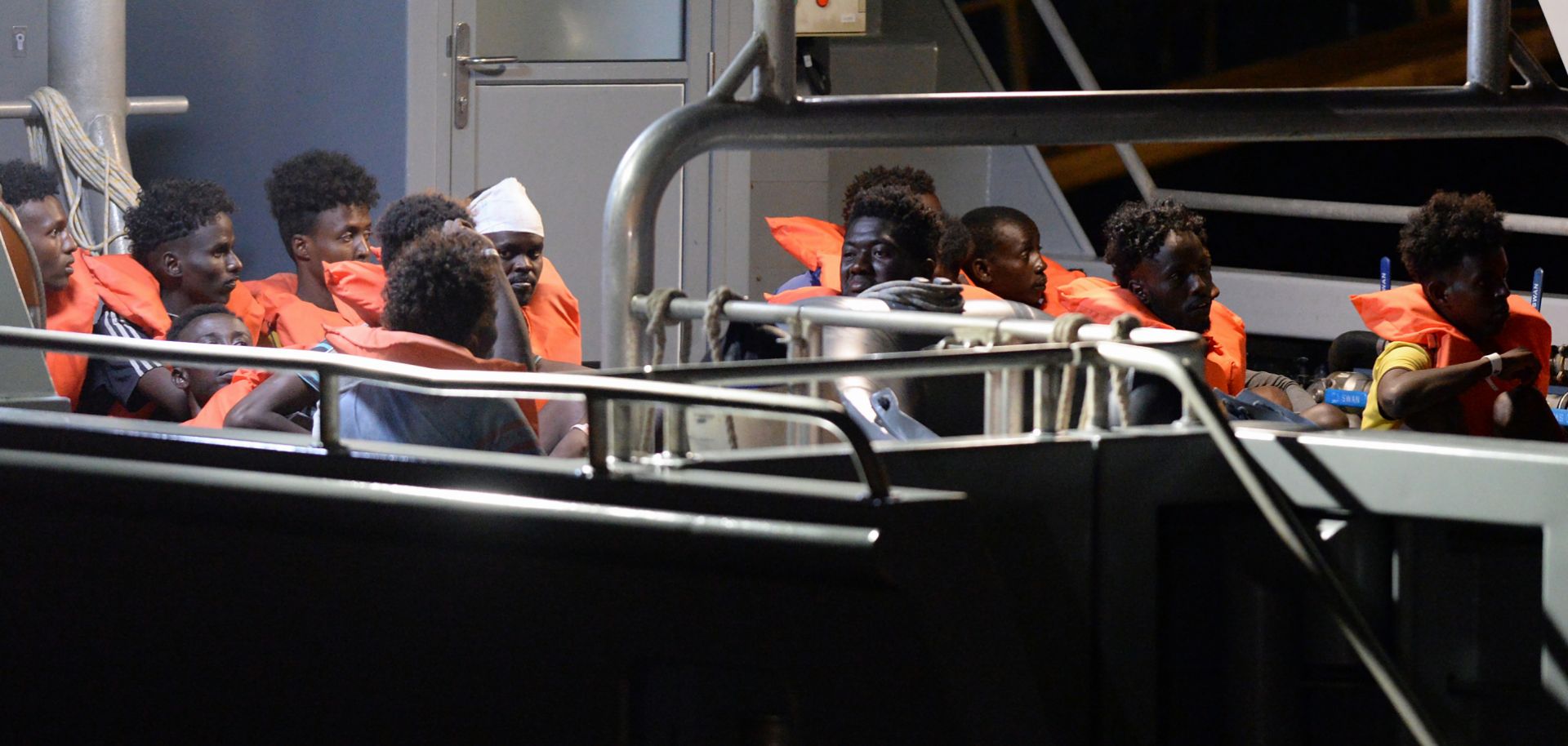 Migrants sit aboard a Maltese patrol boat after being rescued off the Libyan coast by a German-flagged ship on July 7, 2019.