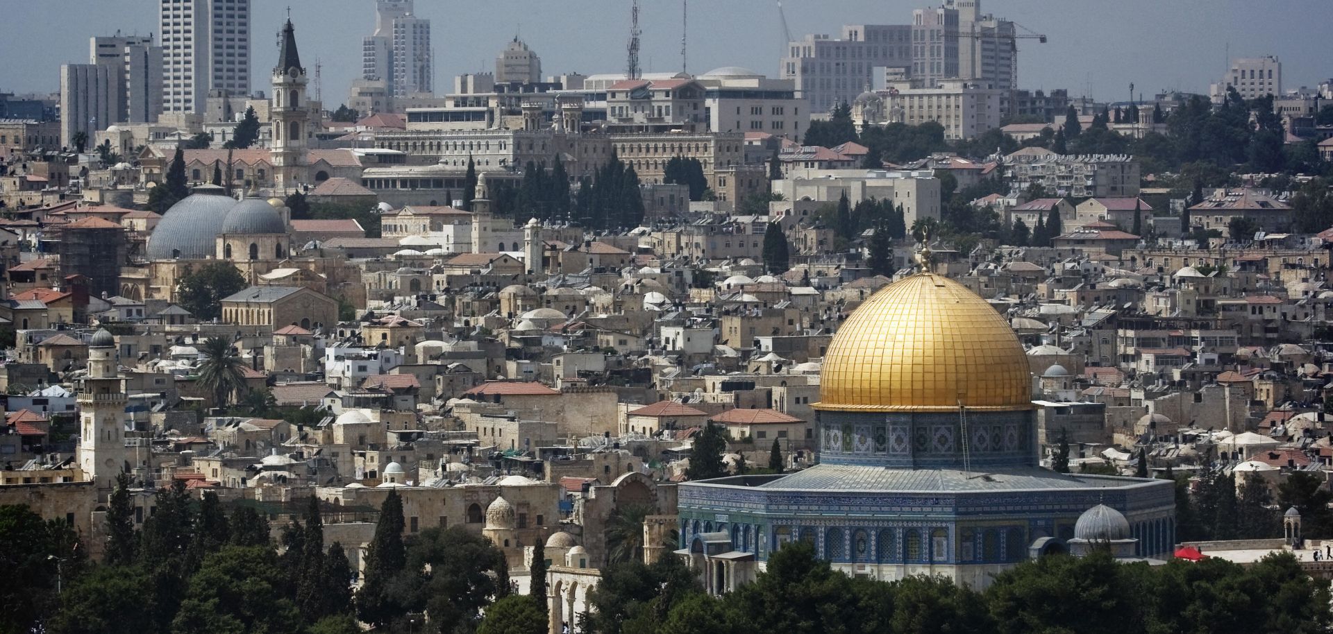 The gilded Dome of the Rock mosque gleams in the sunlight shining on Jerusalem's skyline. 