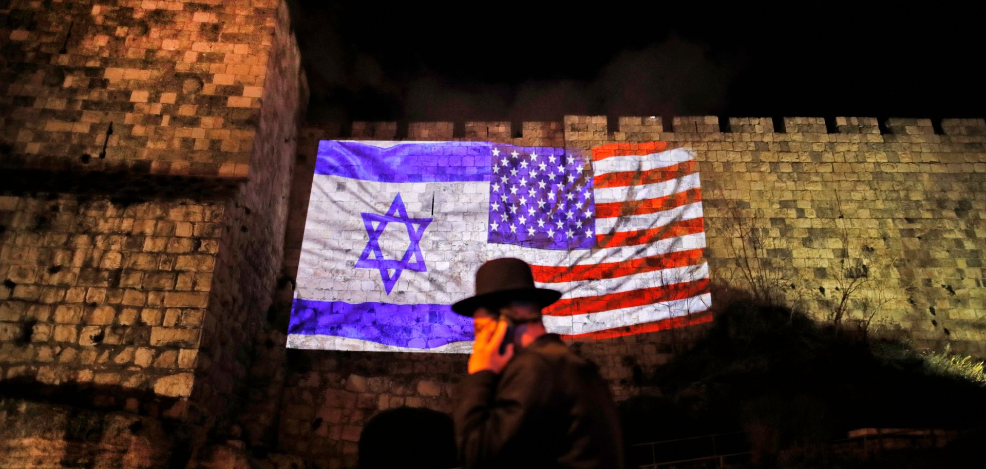 The U.S. and Israeli flags mingle in an image projected on the walls of Jerusalem's Old City.