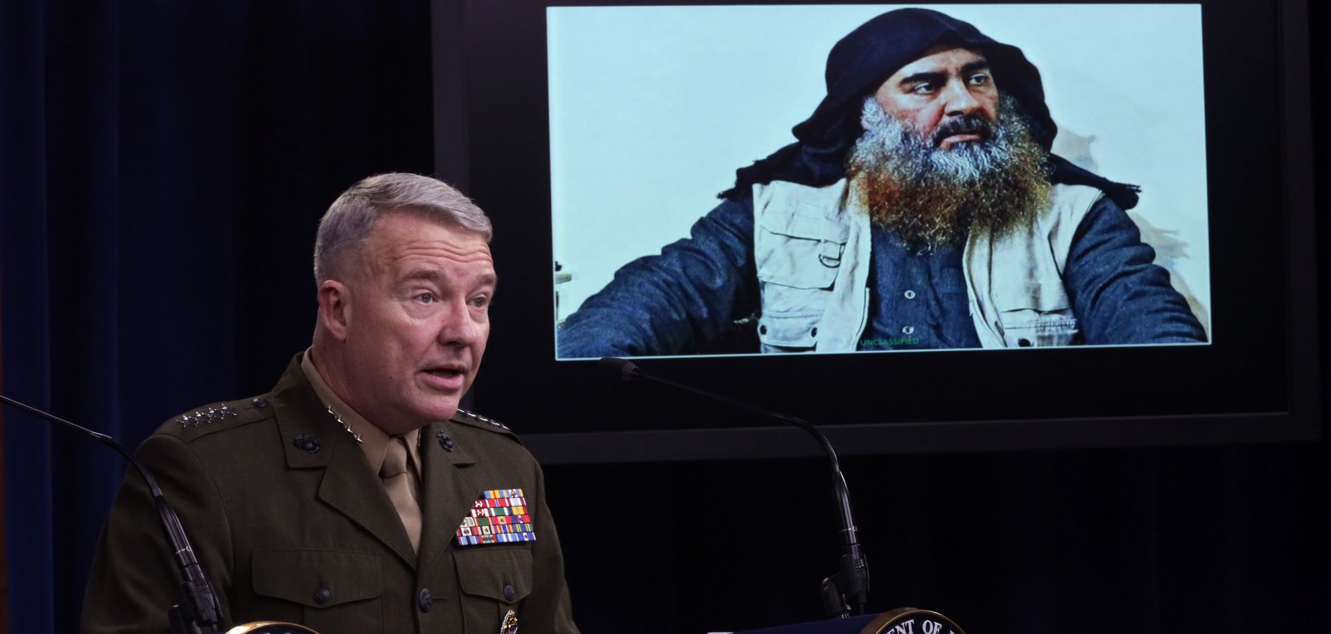 U.S. Marine Corps Gen. Kenneth McKenzie speaks as a picture of Abu Bakr al-Baghdadi is seen during a press briefing Oct. 30, 2019, at the Pentagon in Arlington, Virginia.