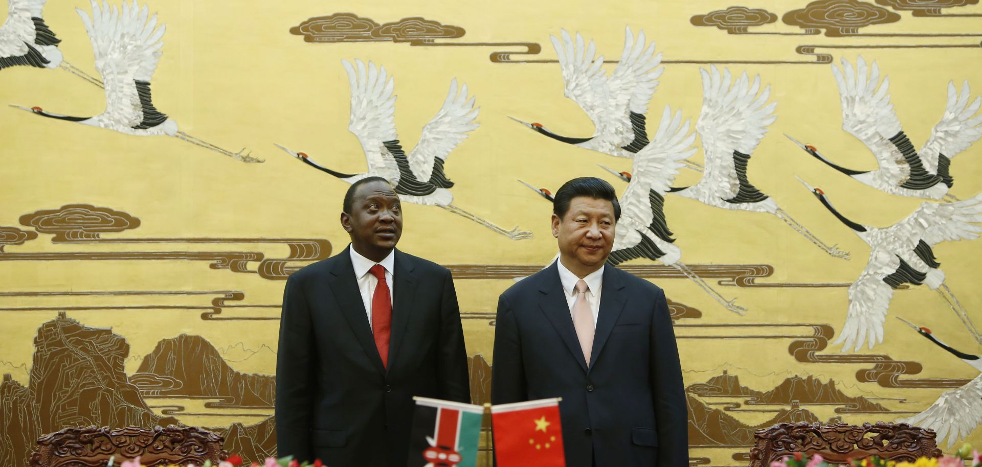 Kenyan President Uhuru Kenyatta and his Chinese President Xi Jinping stand during a signing ceremony.