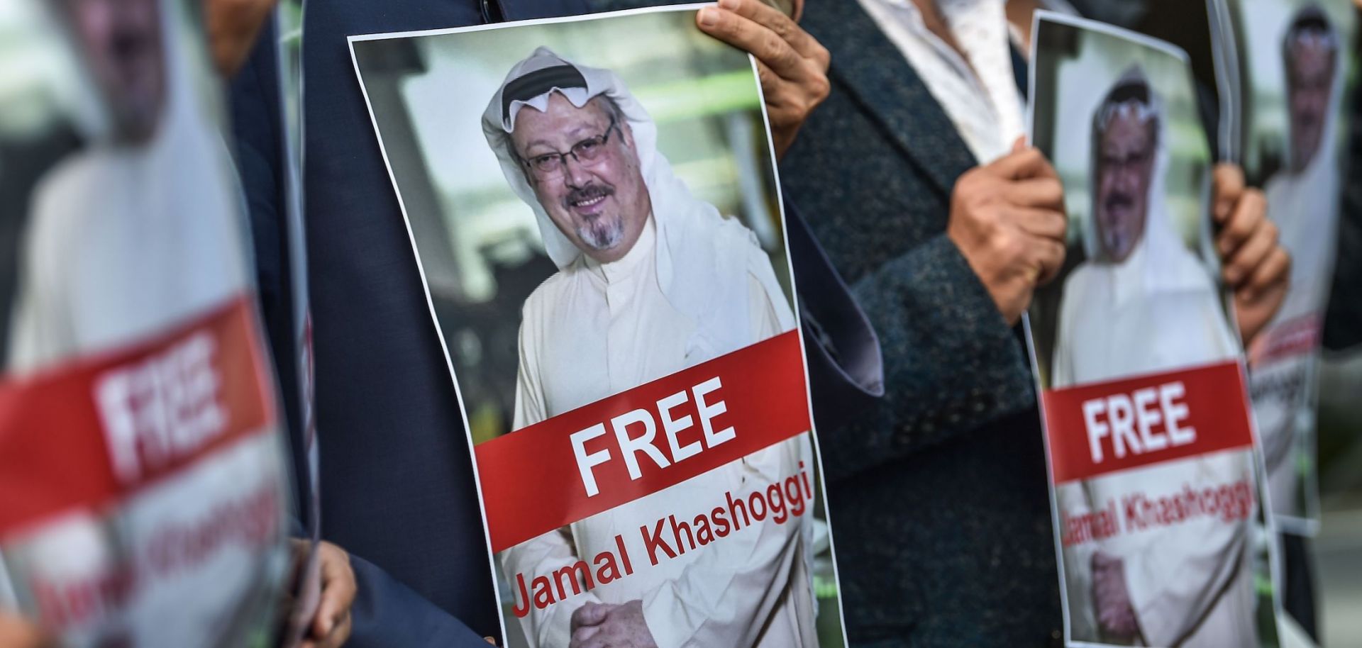Protestors hold posters of missing journalist Jamal Khashoggi
