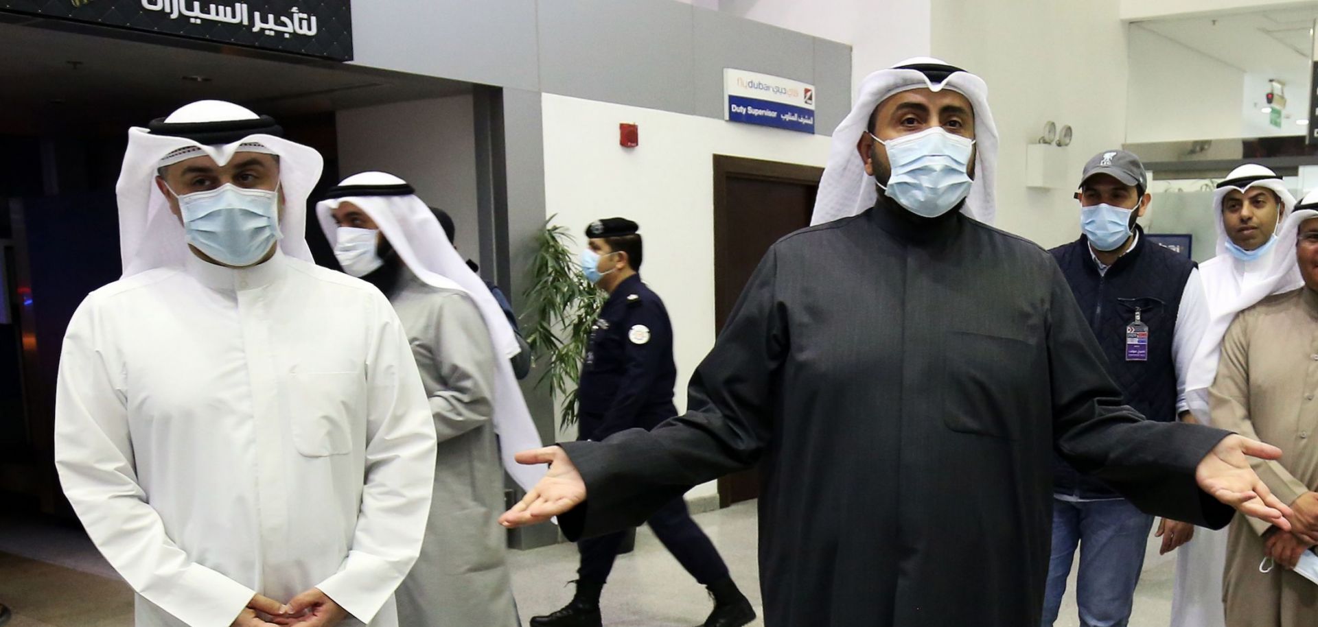 Kuwaiti Health Minister Sheikh Basel al-Sabah, right, speaks with the media on Feb. 22, 2020, as officials at the Kuwait City airport prepare to take Kuwaitis returning from Iran to a hospital to be tested for the COVID-19 virus.