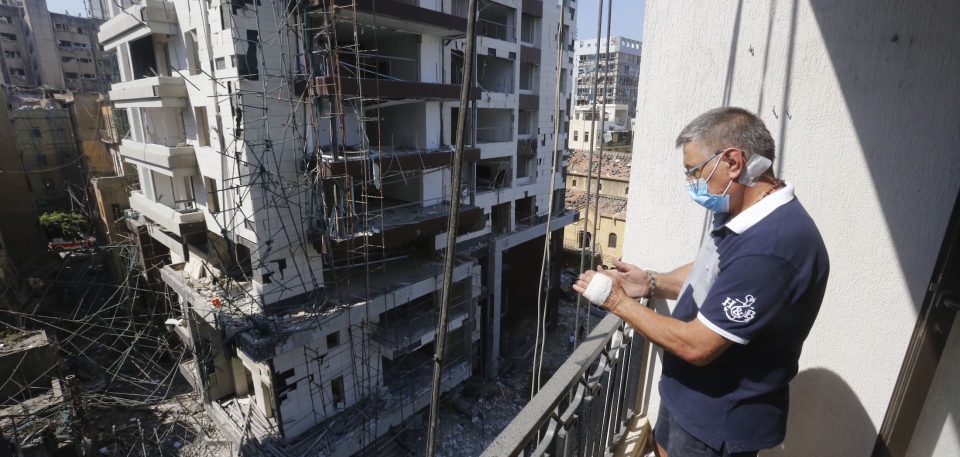A man looks from the balcony of a building, damaged by the port explosion a day earlier, in Beirut, Lebanon on Aug. 5, 2020.