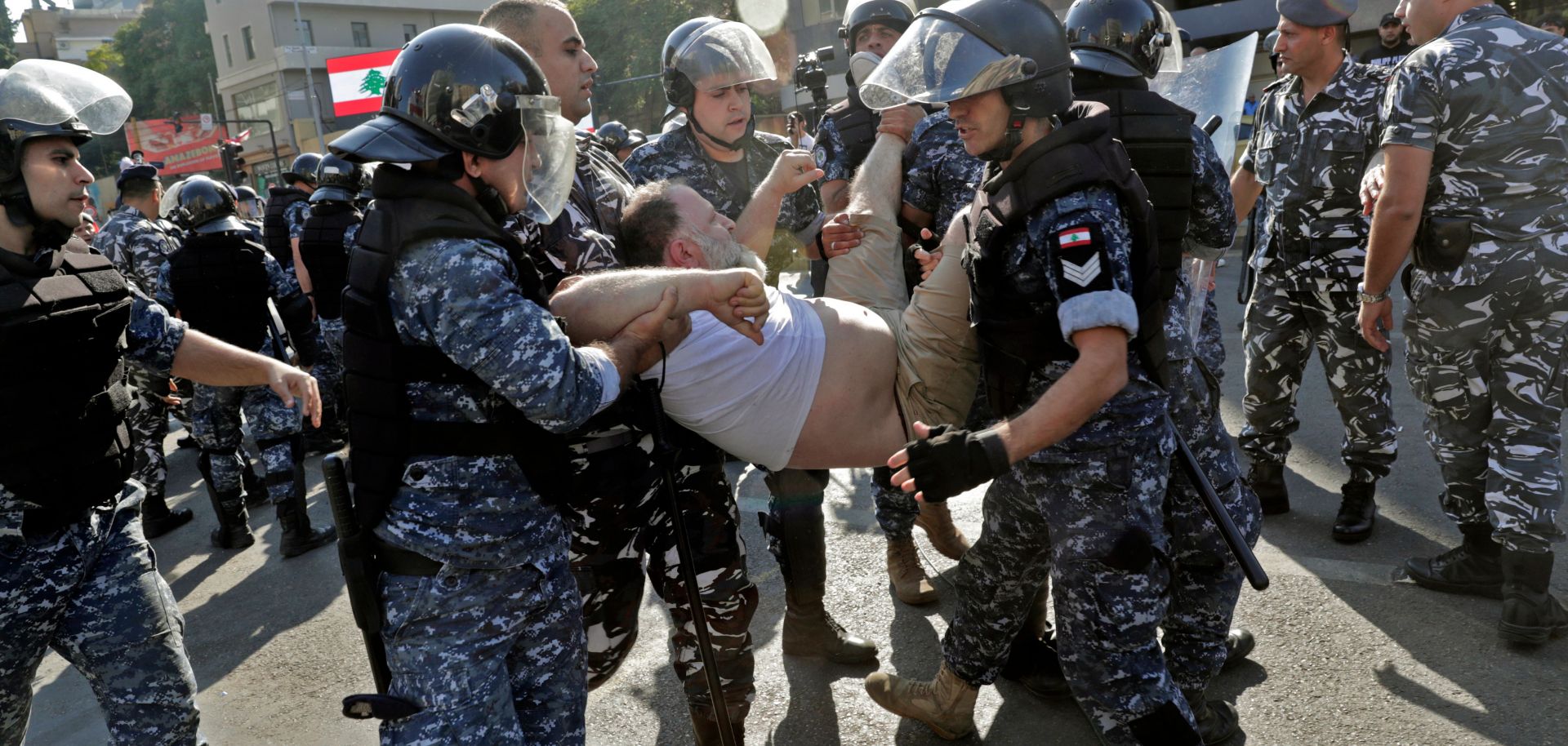 Lebanese riot police officers remove anti-government protesters as they dismantle a roadblock in the Lebanese capital of Beirut on Oct. 31, 2019. Traffic came to a standstill on major highways, as protesters erected metal barricades.