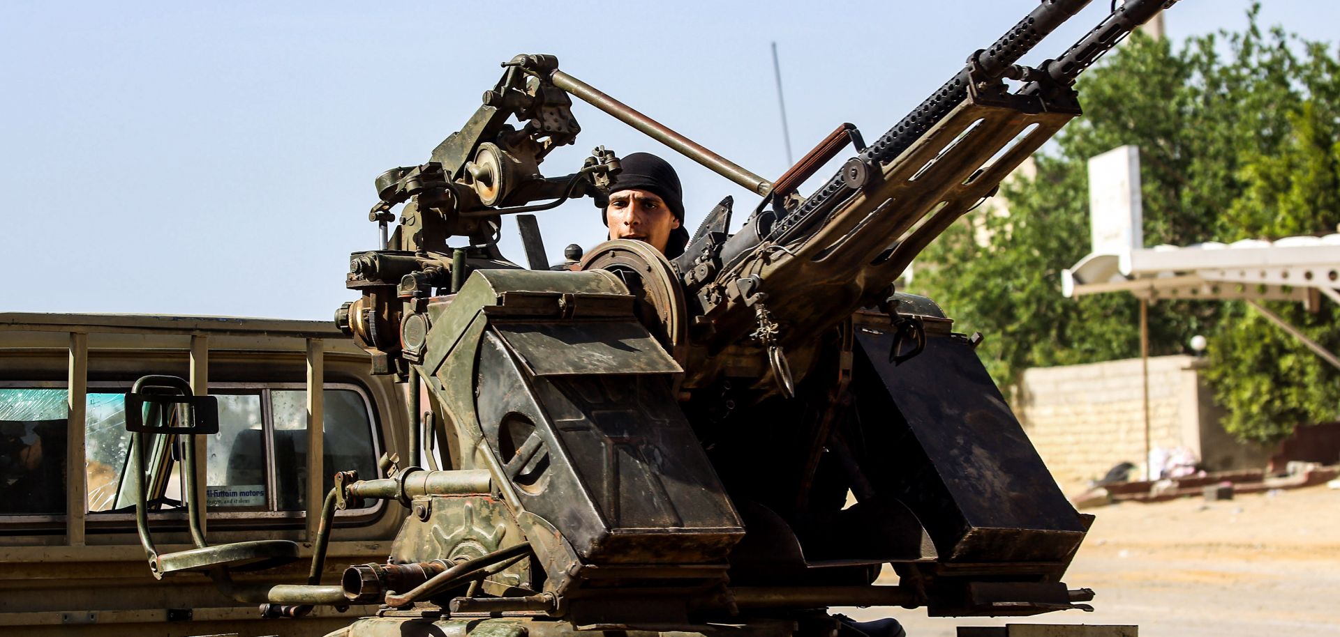 A Libyan fighter loyal to the Government of National Accord mans a heavy weapon mounted on a pickup truck during clashes with Libyan National Army forces south of Tripoli's suburb of Ain Zara on April 10, 2019. 