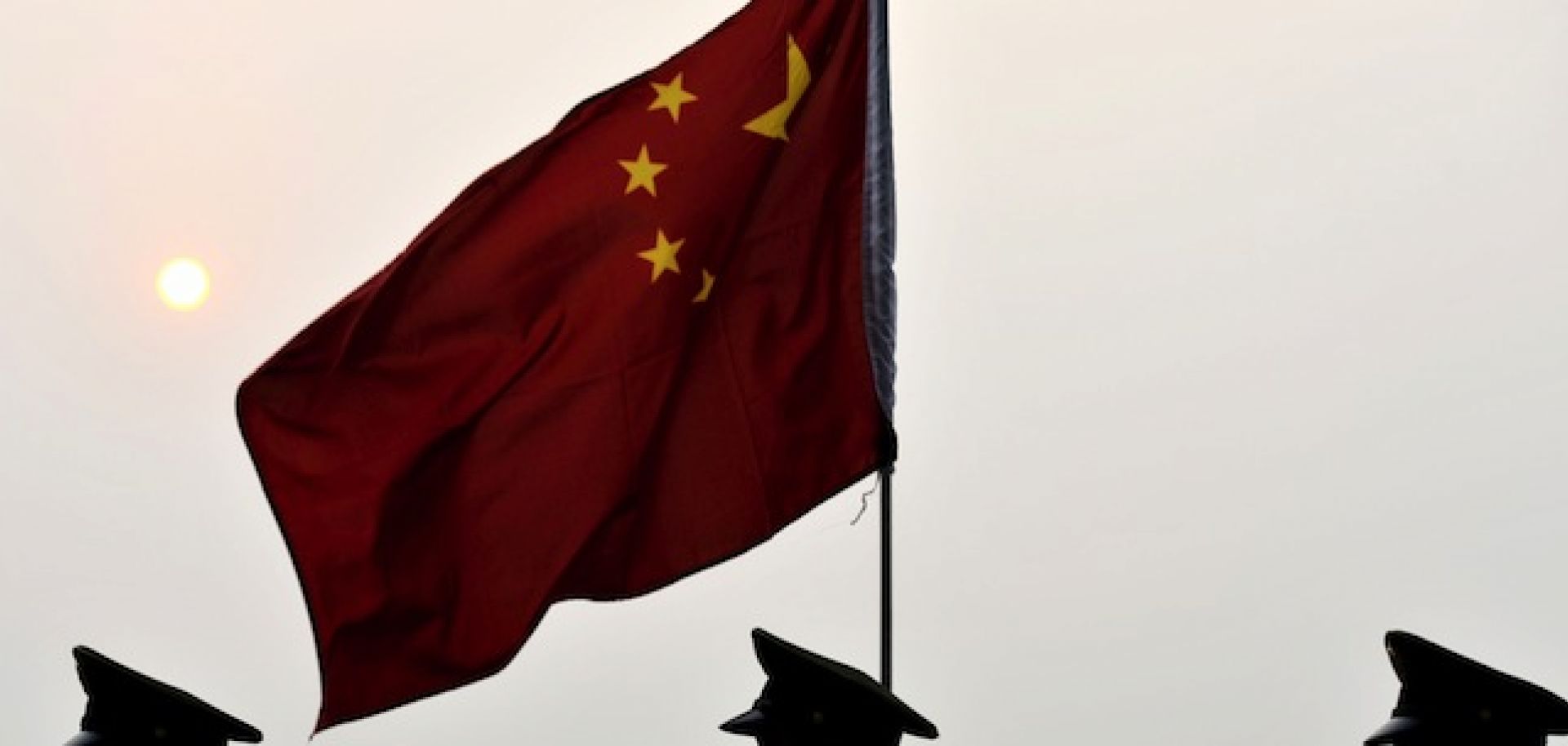 Soldiers walk past a Chinese flag in Shanghai.