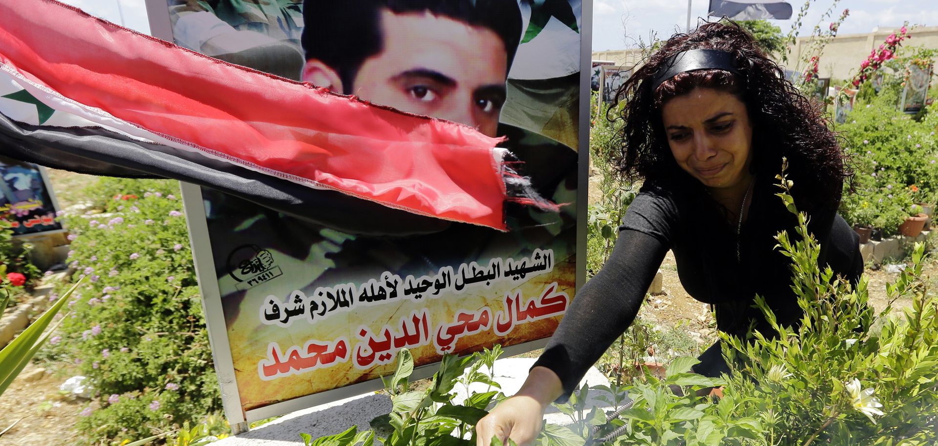A Syrian woman cries at the grave of a relative killed in the Syrian conflict and buried at the Martyr's Cemetery in Tartus. (JOSEPH EID/AFP/Getty Images)